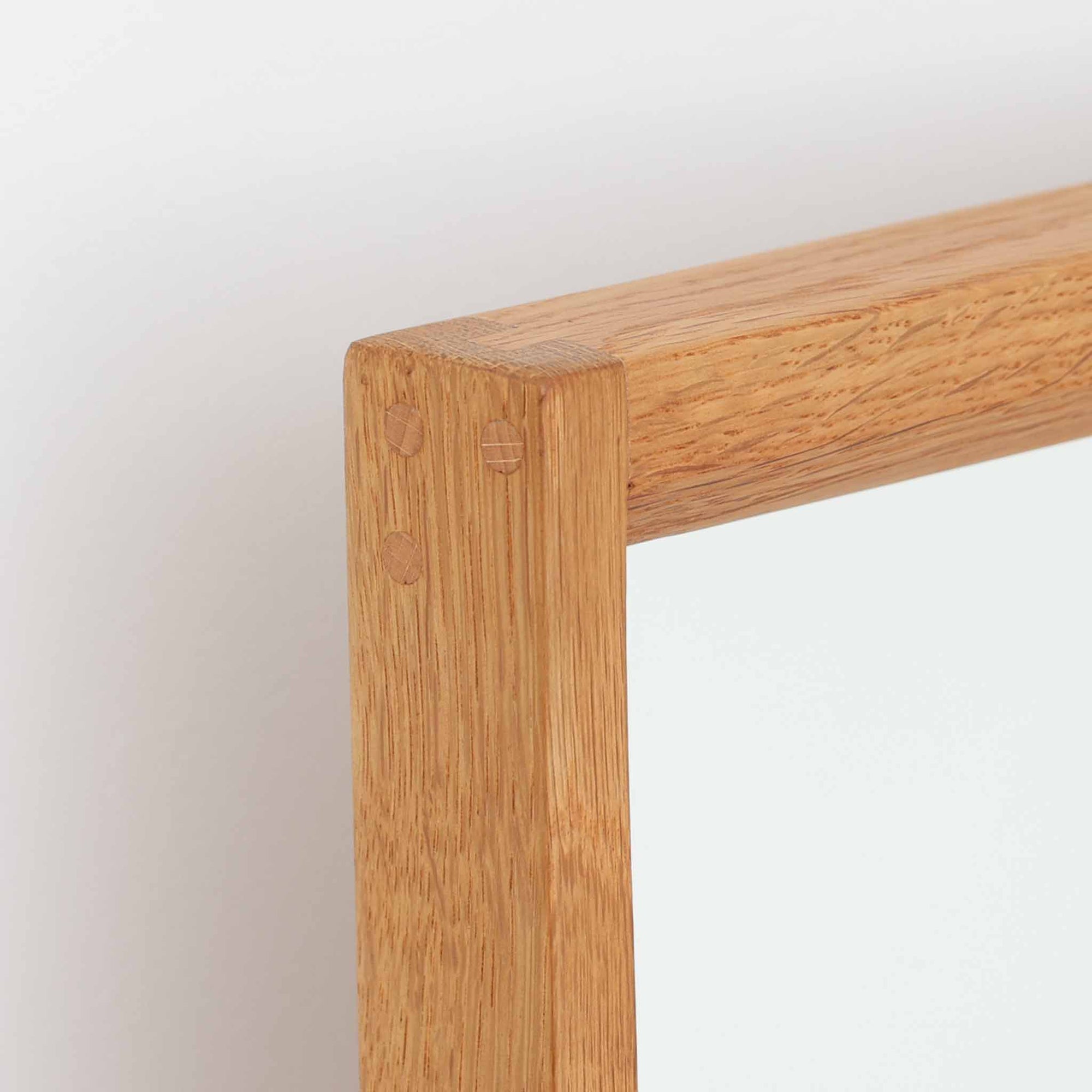 デンマークのデザイナー、Kai Kristiansen（カイ・クリスチャンセン）がAksel Kjersgaard（アクセル・キアスゴー）社のために手がけた立て掛けミラー「No.145」です。オーク材の美しい木目を活かしたフレームは細部まで丁寧に仕上げられ、角の木栓や滑らかな面取りなど北欧家具らしい繊細な職人技が光ります。高さ104cmと程よいサイズ感で、玄関や寝室、リビングなど幅広い空間に馴染みます。背面には壁掛け用の紐が付属していますが、重量があるため立て掛けでの使用をおすすめします。経年により深みを増したオークの質感が空間に温かみを添えるビンテージアイテムです。