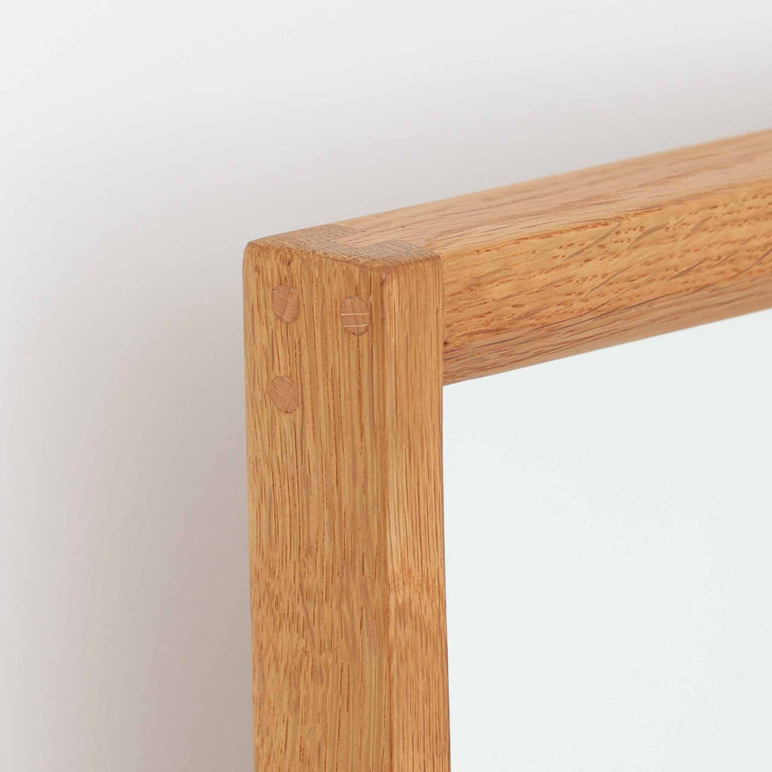 デンマークのデザイナー、Kai Kristiansen（カイ・クリスチャンセン）がAksel Kjersgaard（アクセル・キアスゴー）社のために手がけた立て掛けミラー「No.145」です。オーク材の美しい木目を活かしたフレームは細部まで丁寧に仕上げられ、角の木栓や滑らかな面取りなど北欧家具らしい繊細な職人技が光ります。高さ104cmと程よいサイズ感で、玄関や寝室、リビングなど幅広い空間に馴染みます。背面には壁掛け用の紐が付属していますが、重量があるため立て掛けでの使用をおすすめします。経年により深みを増したオークの質感が空間に温かみを添えるビンテージアイテムです。