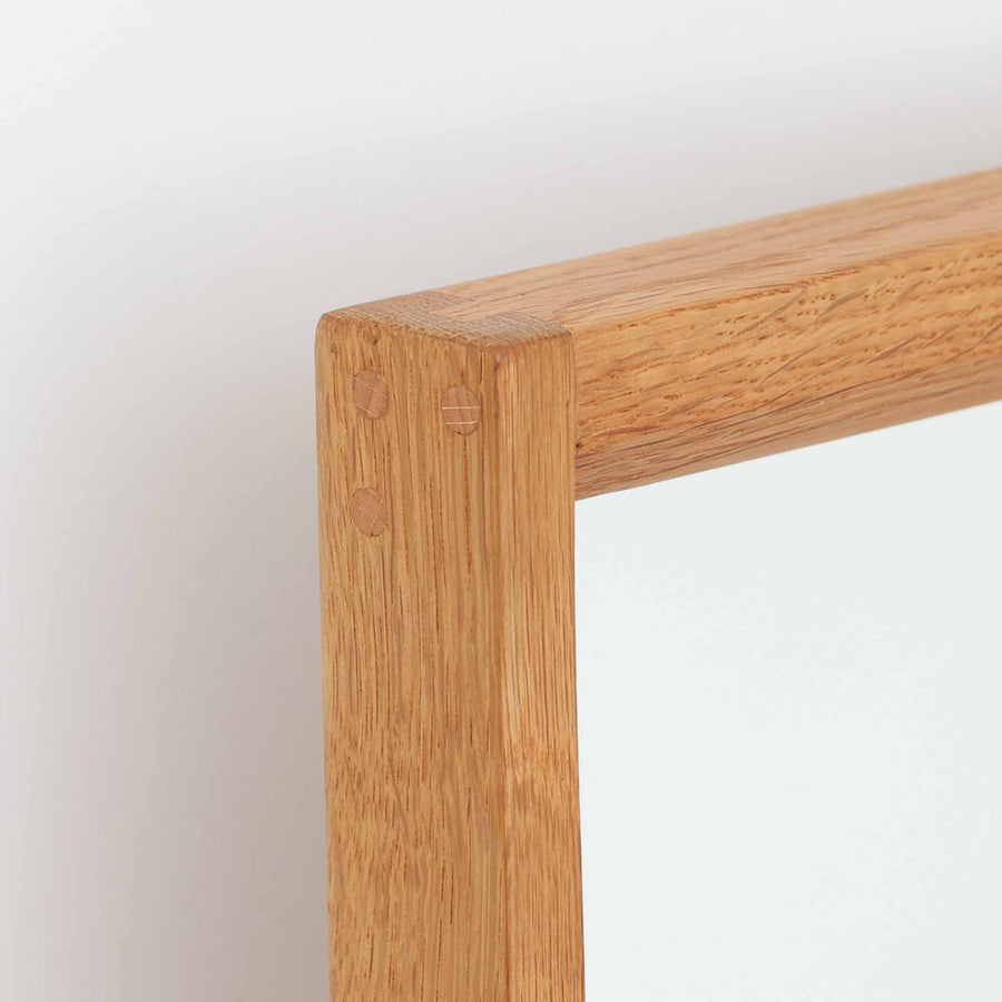 デンマークのデザイナー、Kai Kristiansen（カイ・クリスチャンセン）がAksel Kjersgaard（アクセル・キアスゴー）社のために手がけた立て掛けミラー「No.145」です。オーク材の美しい木目を活かしたフレームは細部まで丁寧に仕上げられ、角の木栓や滑らかな面取りなど北欧家具らしい繊細な職人技が光ります。高さ104cmと程よいサイズ感で、玄関や寝室、リビングなど幅広い空間に馴染みます。背面には壁掛け用の紐が付属していますが、重量があるため立て掛けでの使用をおすすめします。経年により深みを増したオークの質感が空間に温かみを添えるビンテージアイテムです。