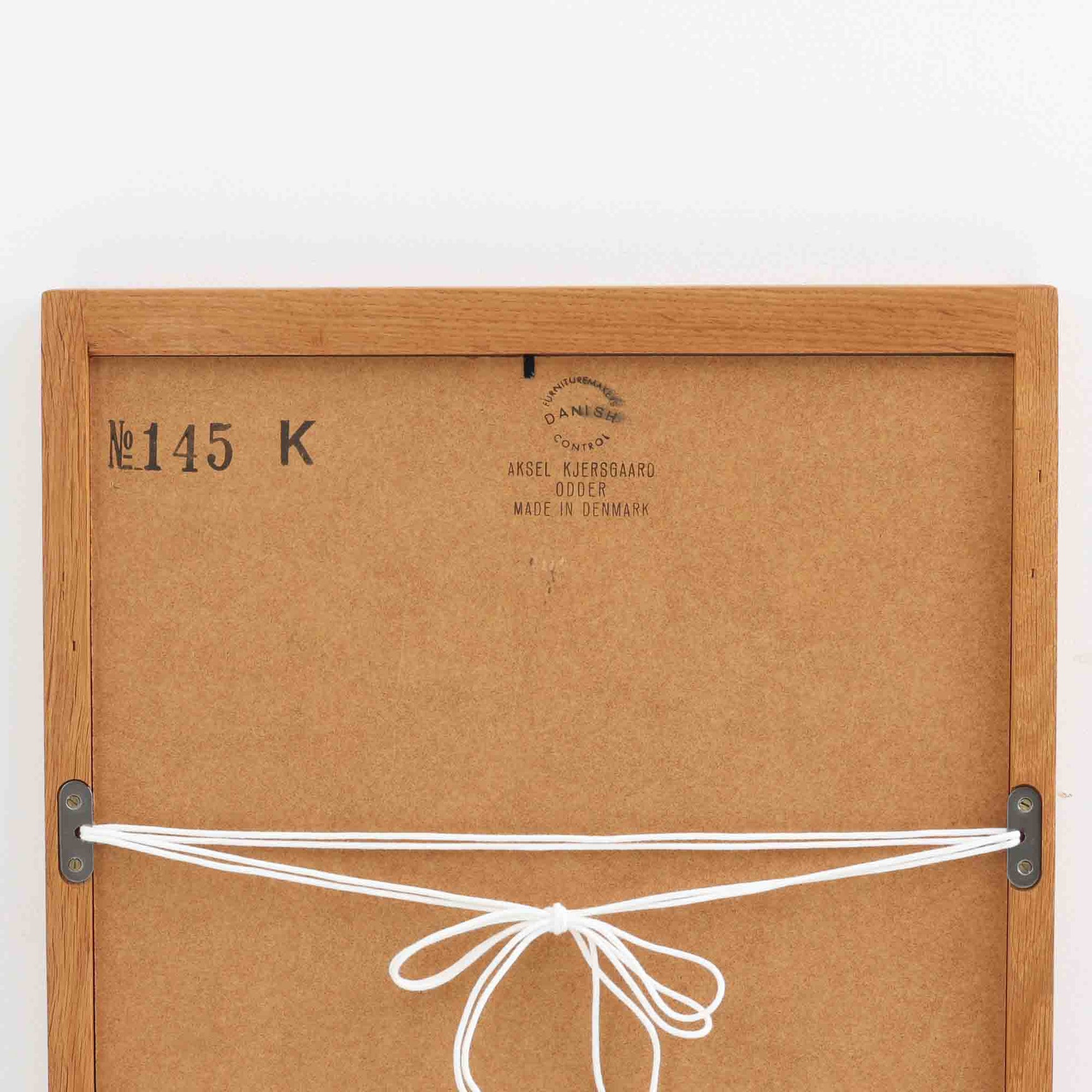 デンマークのデザイナー、Kai Kristiansen（カイ・クリスチャンセン）がAksel Kjersgaard（アクセル・キアスゴー）社のために手がけた立て掛けミラー「No.145」です。オーク材の美しい木目を活かしたフレームは細部まで丁寧に仕上げられ、角の木栓や滑らかな面取りなど北欧家具らしい繊細な職人技が光ります。高さ104cmと程よいサイズ感で、玄関や寝室、リビングなど幅広い空間に馴染みます。背面には壁掛け用の紐が付属していますが、重量があるため立て掛けでの使用をおすすめします。経年により深みを増したオークの質感が空間に温かみを添えるビンテージアイテムです。