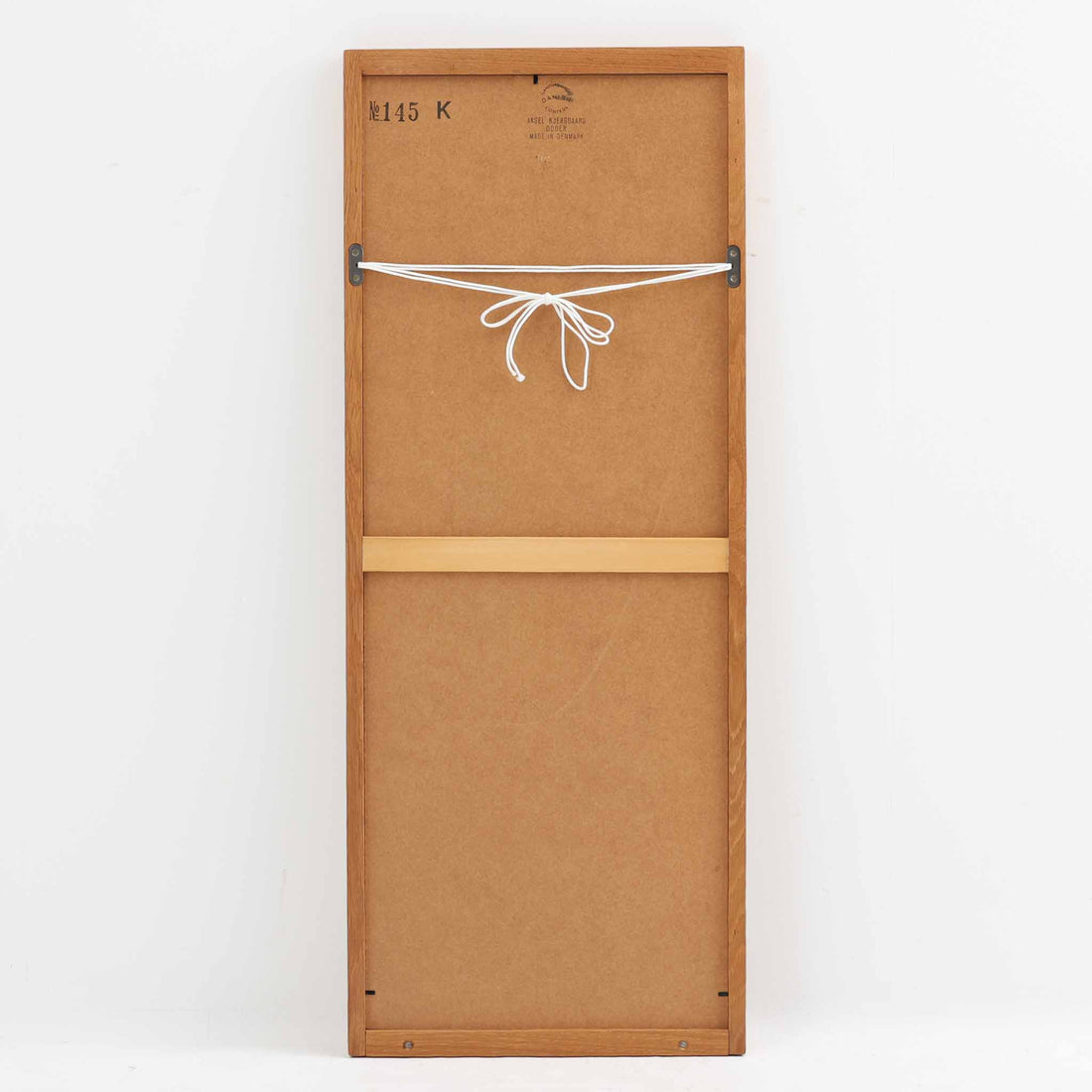 デンマークのデザイナー、Kai Kristiansen（カイ・クリスチャンセン）がAksel Kjersgaard（アクセル・キアスゴー）社のために手がけた立て掛けミラー「No.145」です。オーク材の美しい木目を活かしたフレームは細部まで丁寧に仕上げられ、角の木栓や滑らかな面取りなど北欧家具らしい繊細な職人技が光ります。高さ104cmと程よいサイズ感で、玄関や寝室、リビングなど幅広い空間に馴染みます。背面には壁掛け用の紐が付属していますが、重量があるため立て掛けでの使用をおすすめします。経年により深みを増したオークの質感が空間に温かみを添えるビンテージアイテムです。