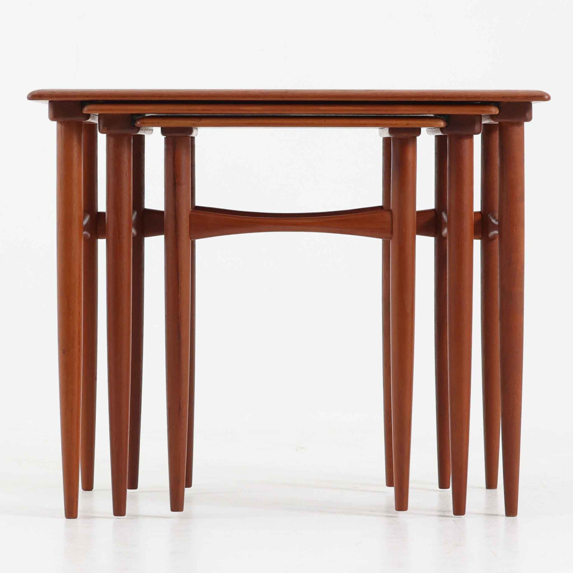 デンマーク製のネストテーブルで、温かみのあるチーク材を用いた北欧ビンテージらしい一品です。サイズ違いの3台が美しく収まり、細く伸びたテーパードレッグや柔らかな面取りが職人技を感じさせます。来客時のサブテーブルやソファ横のサイド使いなど多用途に活躍し、経年による深い色艶が空間に上質な存在感を添えます。