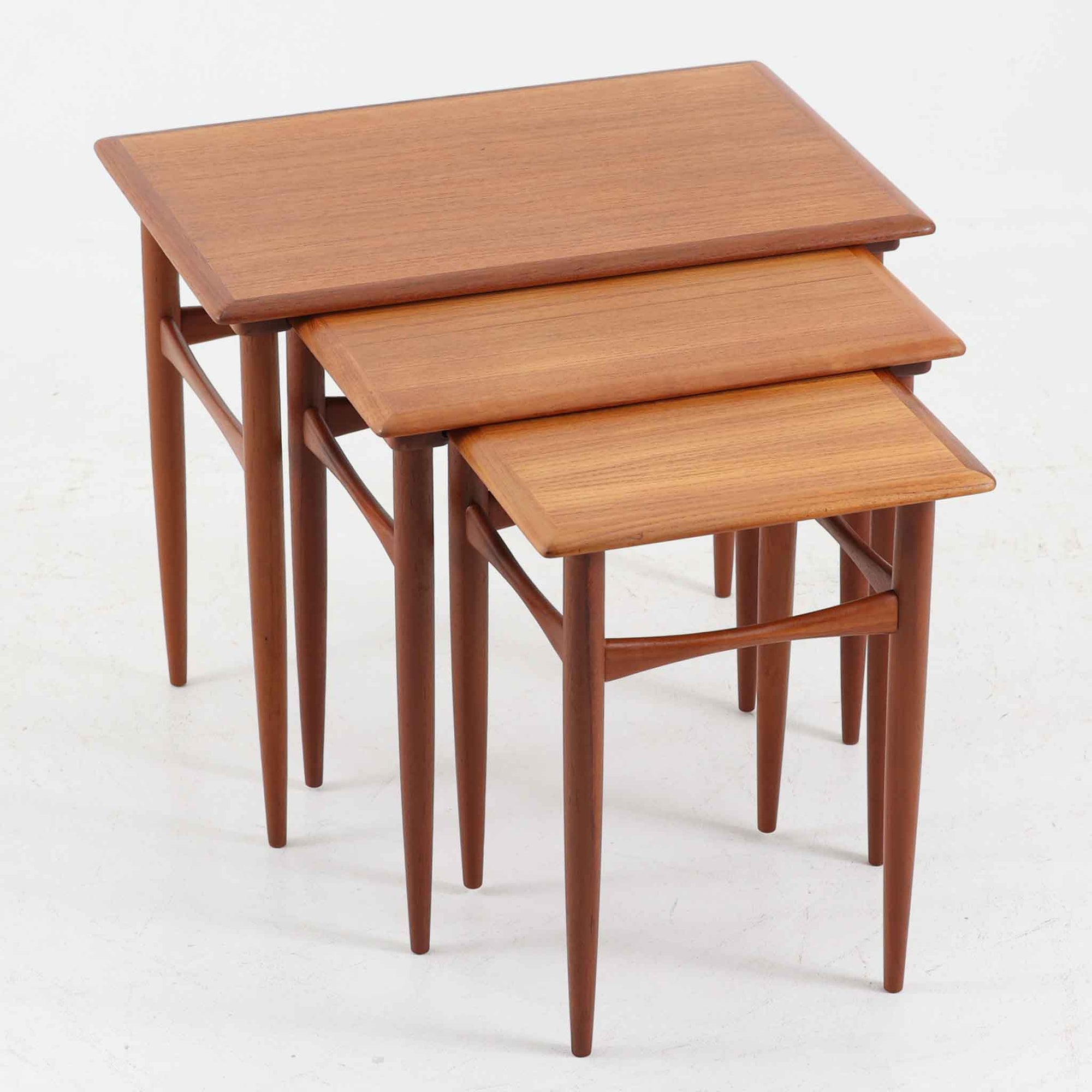 デンマーク製のネストテーブルで、温かみのあるチーク材を用いた北欧ビンテージらしい一品です。サイズ違いの3台が美しく収まり、細く伸びたテーパードレッグや柔らかな面取りが職人技を感じさせます。来客時のサブテーブルやソファ横のサイド使いなど多用途に活躍し、経年による深い色艶が空間に上質な存在感を添えます。
