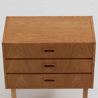 デンマーク製3段チェストです。オーク材の明るく柔らかな木目が美しく、北欧家具らしいナチュラルな温もりを感じさせます。引き出しは浅すぎず程よい深さがあり、衣類や小物をすっきりと収納できます。中央に設けられた長方形の掘り込み取っ手がすっきりとした印象を与え、シンプルなフォルムながらも職人技が光ります。小ぶりなサイズ感で、寝室や玄関、リビングのサイドチェストとしても使いやすい一台です。経年により増した風合いが空間に上質な味わいを添えます。