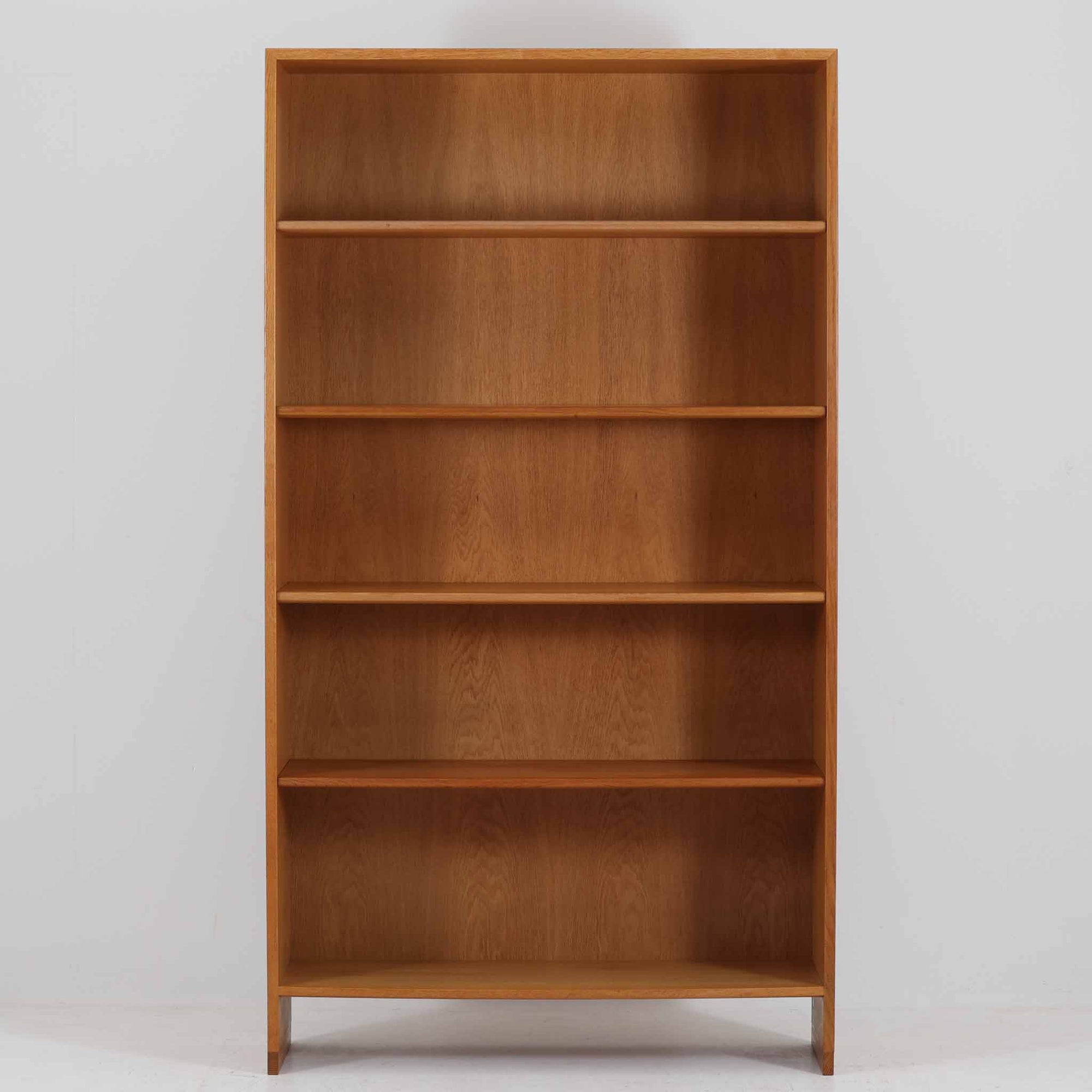 Hans J. Wegner（ハンス・J・ウェグナー）によるデザインで、Ry Mobler社から発表されたブックシェルフ「RY8」です。オーク材を用いたナチュラルな風合いと端正なラインが美しく、ウェグナーらしい機能美を感じさせます。通常モデルでは1枚が固定棚で他は可動棚となっていますが、本品は全ての棚板が取り外し可能な希少タイプで、用途に応じて高さを自在に調整できます。背面には製造年月のスタンプが残り、当時のクラフトマンシップを今に伝えています。書籍収納はもちろん、リビングやオフィスのディスプレイシェルフとしても活躍する一台です。