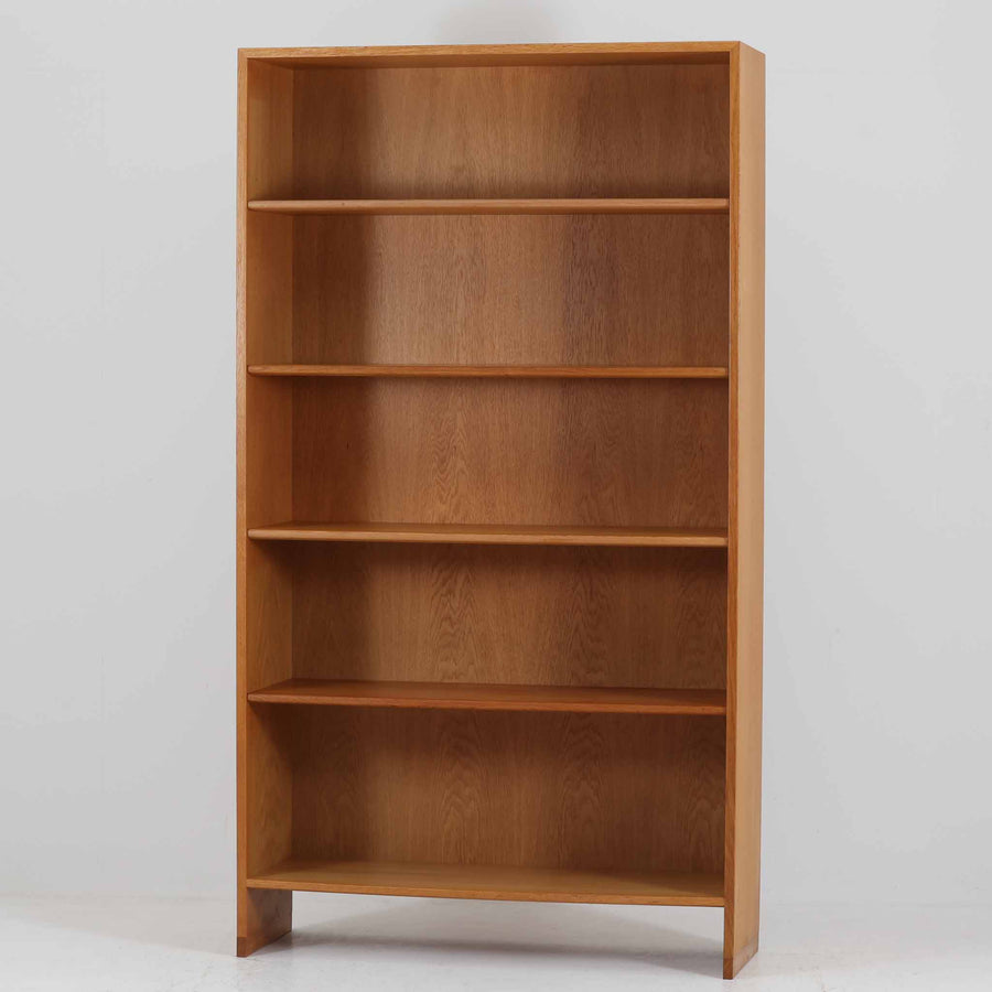 Hans J. Wegner（ハンス・J・ウェグナー）によるデザインで、Ry Mobler社から発表されたブックシェルフ「RY8」です。オーク材を用いたナチュラルな風合いと端正なラインが美しく、ウェグナーらしい機能美を感じさせます。通常モデルでは1枚が固定棚で他は可動棚となっていますが、本品は全ての棚板が取り外し可能な希少タイプで、用途に応じて高さを自在に調整できます。背面には製造年月のスタンプが残り、当時のクラフトマンシップを今に伝えています。書籍収納はもちろん、リビングやオフィスのディスプレイシェルフとしても活躍する一台です。