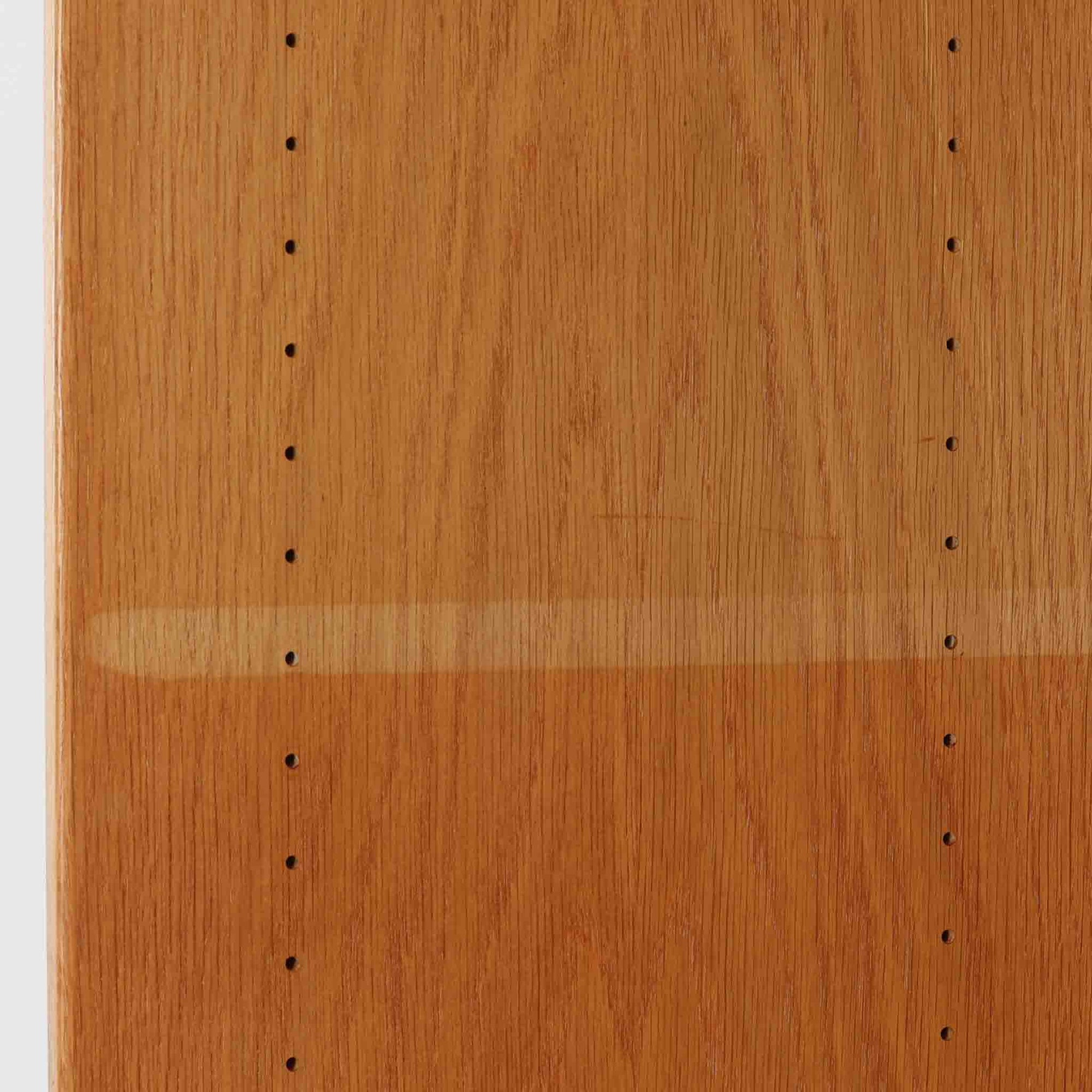 Hans J. Wegner（ハンス・J・ウェグナー）によるデザインで、Ry Mobler社から発表されたブックシェルフ「RY8」です。オーク材を用いたナチュラルな風合いと端正なラインが美しく、ウェグナーらしい機能美を感じさせます。通常モデルでは1枚が固定棚で他は可動棚となっていますが、本品は全ての棚板が取り外し可能な希少タイプで、用途に応じて高さを自在に調整できます。背面には製造年月のスタンプが残り、当時のクラフトマンシップを今に伝えています。書籍収納はもちろん、リビングやオフィスのディスプレイシェルフとしても活躍する一台です。