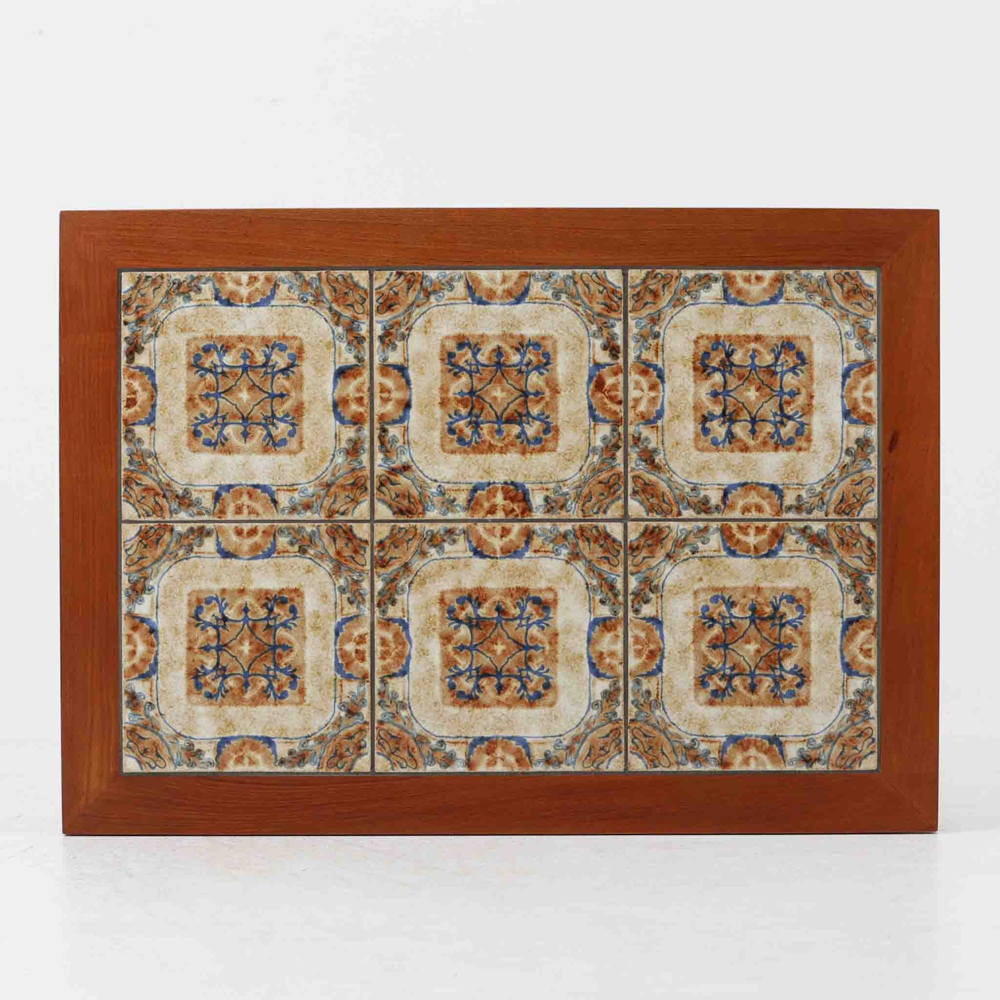 チーク材のフレームに陶磁器タイルを組み合わせたサイドテーブルは、温かみのある木肌と絵柄タイルの表情が調和した北欧ビンテージらしい一品です。天板中央に配されたタイルは、実用性に優れつつ装飾性も高く、経年による釉薬の風合いが落ち着いた存在感を演出します。直線的で端正な脚部構造は安定感があり、ソファ脇の補助台やディスプレイ台、花器やランプを置く台としても取り入れやすく、暮らしの中で静かなアクセントとなるビンテージ家具です。