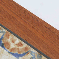 チーク材のフレームに陶磁器タイルを組み合わせたサイドテーブルは、温かみのある木肌と絵柄タイルの表情が調和した北欧ビンテージらしい一品です。天板中央に配されたタイルは、実用性に優れつつ装飾性も高く、経年による釉薬の風合いが落ち着いた存在感を演出します。直線的で端正な脚部構造は安定感があり、ソファ脇の補助台やディスプレイ台、花器やランプを置く台としても取り入れやすく、暮らしの中で静かなアクセントとなるビンテージ家具です。