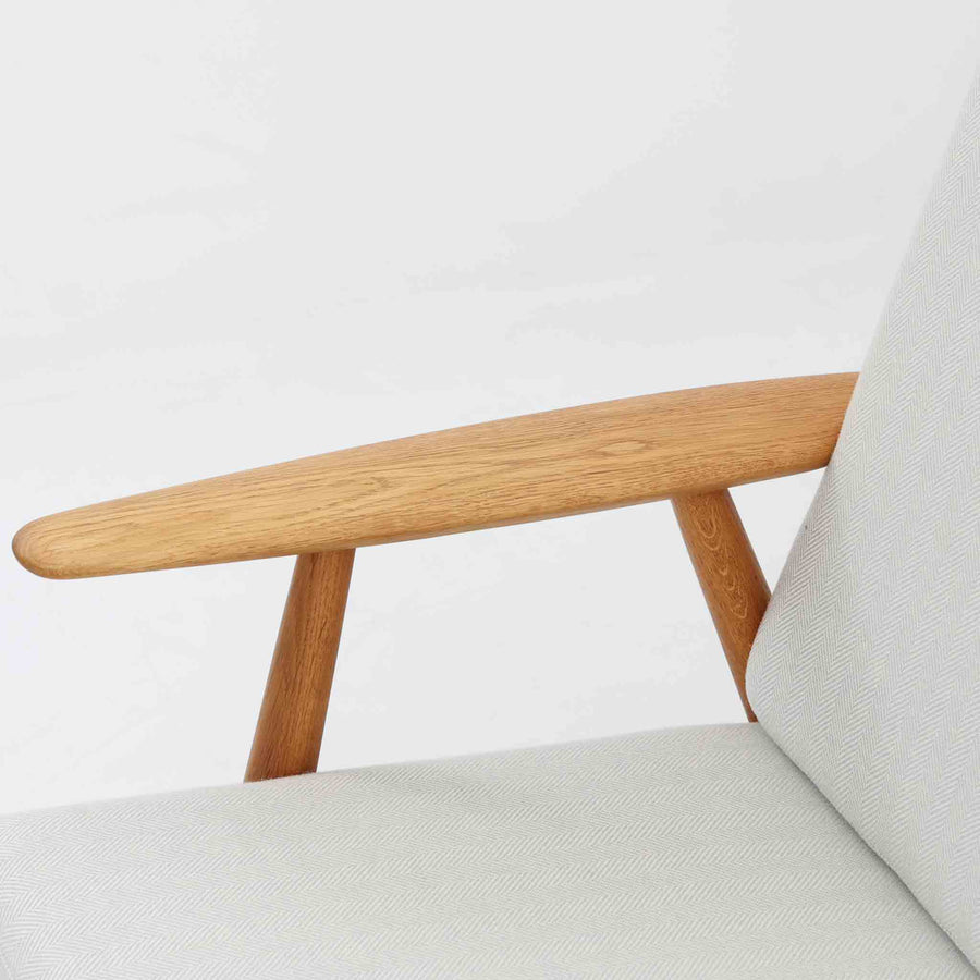 Hans J. Wegner（ハンス・J・ウェグナー）がデザインし、Getama社から発表されたGE240トリプルソファです。通称「Cigar Sofa」とも呼ばれる名作で、丸みを帯びたアームと堅牢なオーク材フレームが特徴です。背面まで美しい格子状のデザインは空間に軽やかさを与え、どの角度から見ても存在感があります。ライトグレー系の張地はアクリルとウールをブレンドした素材で、柔らかな風合いと高い耐久性を備えています。北欧家具らしいシンプルさと快適さを兼ね備え、リビングを上質に彩るビンテージソファです。