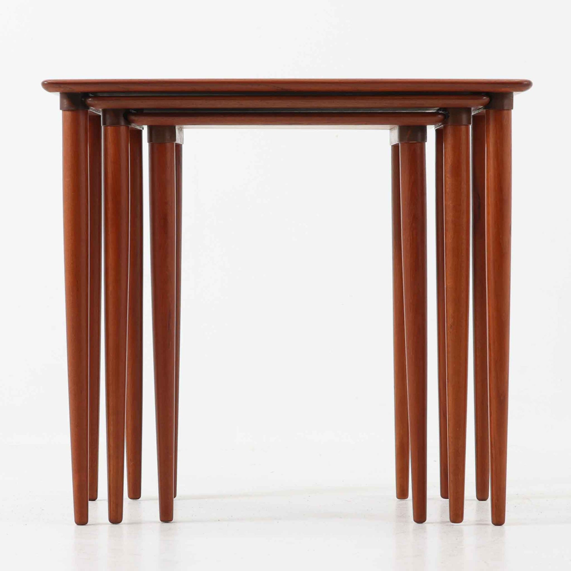 チーク材が使用されたデンマーク製のネストテーブルです。大・中・小の3台がセットになっており、入れ子式で省スペースに収納できるため状況に応じて使い分けができるのが魅力です。丸みを帯びた天板のエッジと細身ですっきりと伸びるテーパードレッグが美しいバランスでデザインされ、北欧らしい温かみのあるチークの木目が落ち着いた雰囲気を演出します。サイドテーブルや花台、来客時の補助テーブルなど多用途に活躍し、リビングに柔らかな存在感を添えてくれるビンテージアイテムです。