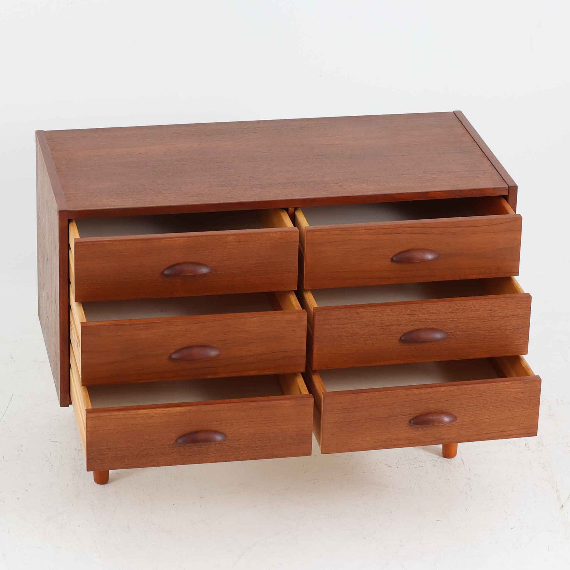 デンマーク製多段チェストです。幅85cmのコンパクトなサイズながら、6杯の引き出しが備わっており、細やかな収納に優れた一台です。チーク材の滑らかな質感と温もりある色合いが空間に上品な落ち着きをもたらします。丸みを帯びたハンドルとテーパー脚のデザインが北欧らしい柔らかさを演出し、寝室やリビング、玄関先など場所を問わず活躍します。経年による深みある艶が魅力の、実用性と美しさを兼ね備えたビンテージ家具です。