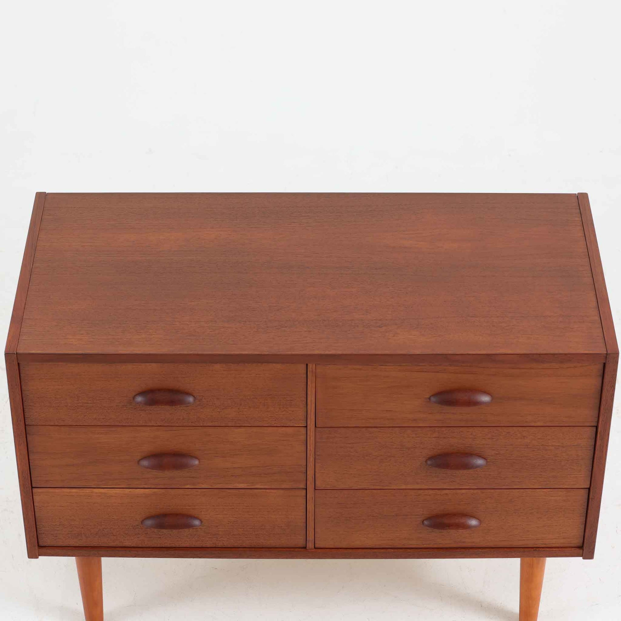 デンマーク製多段チェストです。幅85cmのコンパクトなサイズながら、6杯の引き出しが備わっており、細やかな収納に優れた一台です。チーク材の滑らかな質感と温もりある色合いが空間に上品な落ち着きをもたらします。丸みを帯びたハンドルとテーパー脚のデザインが北欧らしい柔らかさを演出し、寝室やリビング、玄関先など場所を問わず活躍します。経年による深みある艶が魅力の、実用性と美しさを兼ね備えたビンテージ家具です。