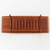 Grete Jalkがデザインし、Glostrup Mobelfabrikで製作されたこちらのセンターテーブルは、端正なプロポーションと軽やかな構造が魅力の北欧ビンテージ品です。幅160cmのゆとりある天板下にはスラット状の棚板を備え、雑誌やブランケットなどを整理しながら使える実用性も兼ね備えています。丸みを帯びた脚部や天板縁の丁寧な仕上げからは、女性デザイナーらしい繊細な美意識と当時の高い木工技術が感じられ、経年により深みを増した木肌が空間に落ち着いた存在感をもたらします。