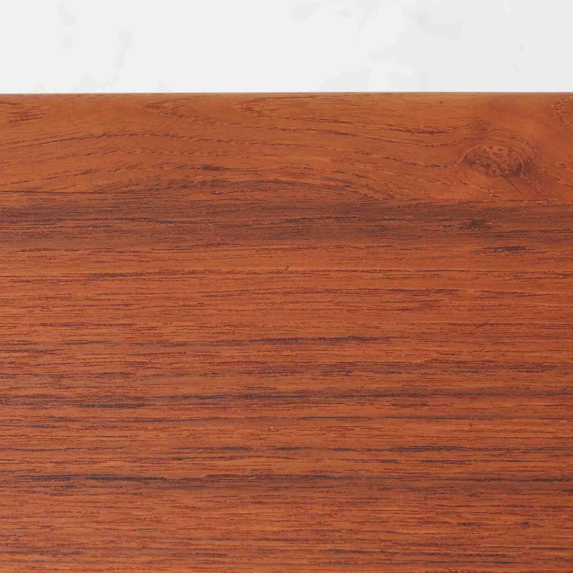 Grete Jalkがデザインし、Glostrup Mobelfabrikで製作されたこちらのセンターテーブルは、端正なプロポーションと軽やかな構造が魅力の北欧ビンテージ品です。幅160cmのゆとりある天板下にはスラット状の棚板を備え、雑誌やブランケットなどを整理しながら使える実用性も兼ね備えています。丸みを帯びた脚部や天板縁の丁寧な仕上げからは、女性デザイナーらしい繊細な美意識と当時の高い木工技術が感じられ、経年により深みを増した木肌が空間に落ち着いた存在感をもたらします。