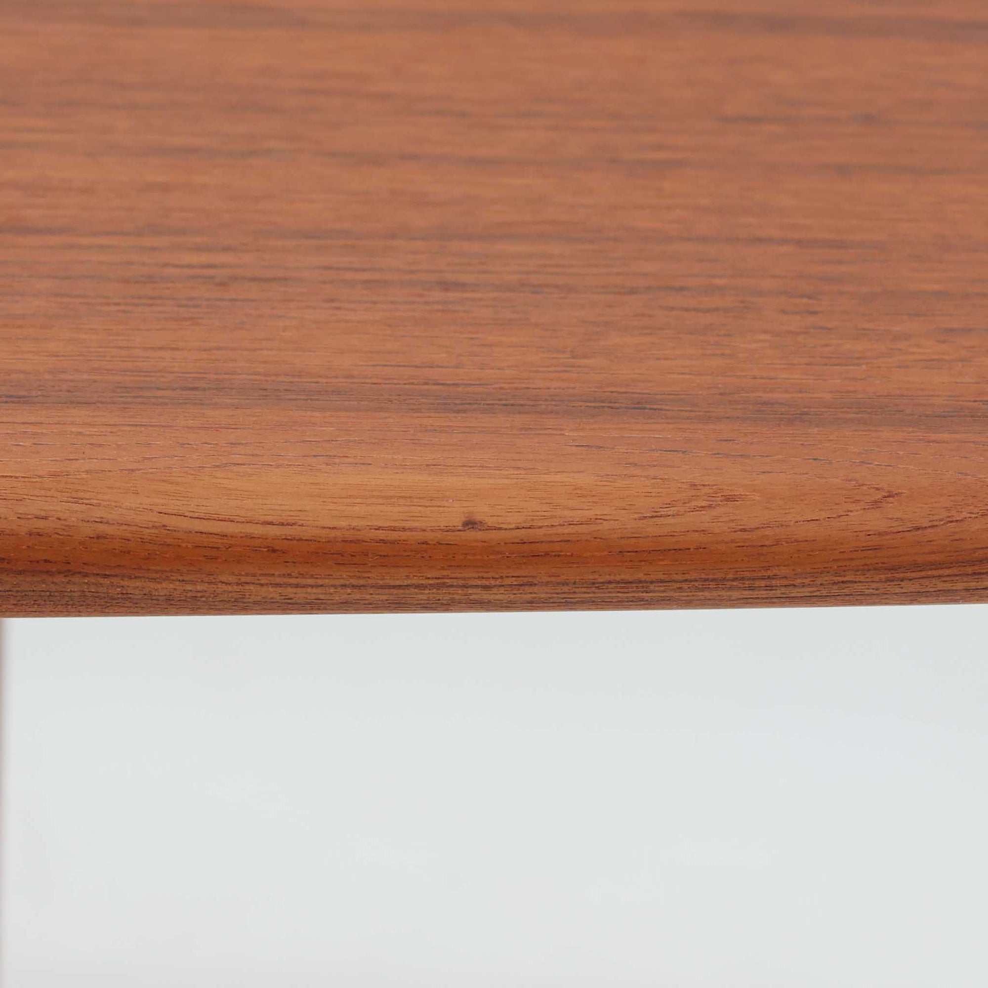 Grete Jalkがデザインし、Glostrup Mobelfabrikで製作されたこちらのセンターテーブルは、端正なプロポーションと軽やかな構造が魅力の北欧ビンテージ品です。幅160cmのゆとりある天板下にはスラット状の棚板を備え、雑誌やブランケットなどを整理しながら使える実用性も兼ね備えています。丸みを帯びた脚部や天板縁の丁寧な仕上げからは、女性デザイナーらしい繊細な美意識と当時の高い木工技術が感じられ、経年により深みを増した木肌が空間に落ち着いた存在感をもたらします。