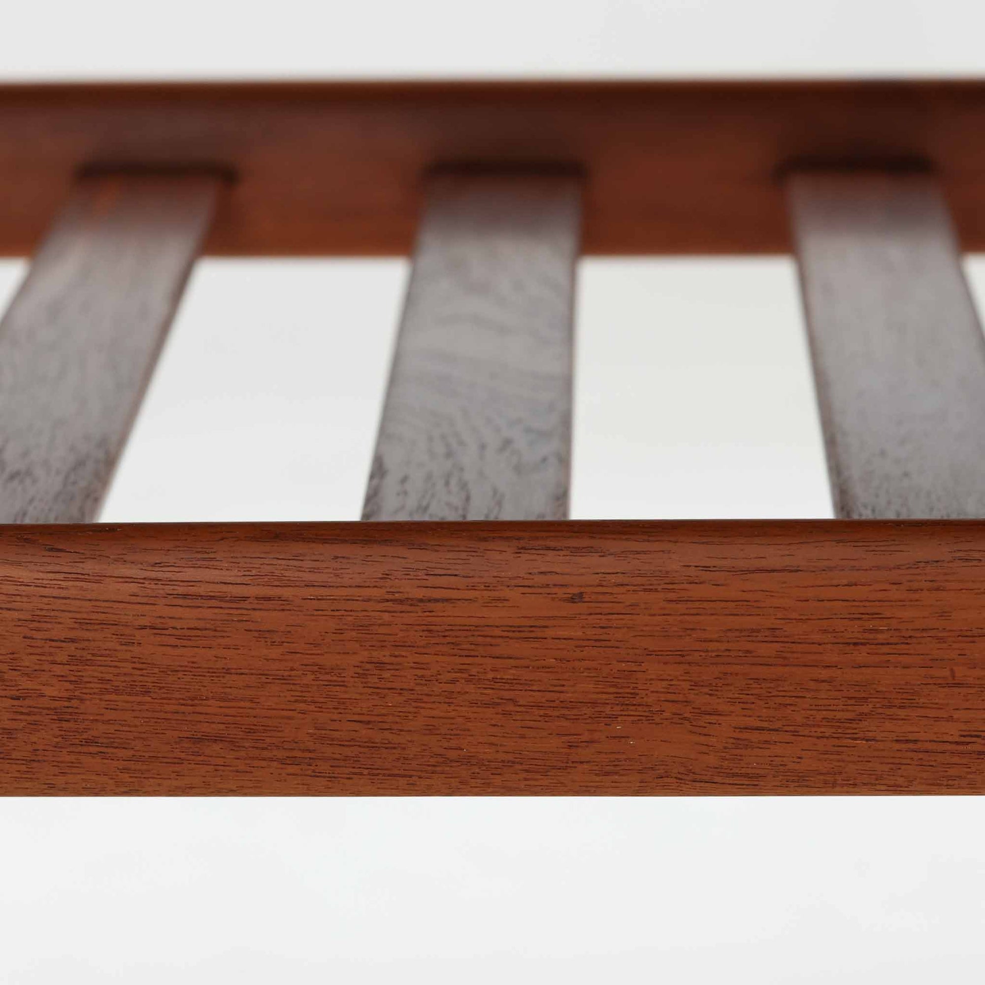 Grete Jalkがデザインし、Glostrup Mobelfabrikで製作されたこちらのセンターテーブルは、端正なプロポーションと軽やかな構造が魅力の北欧ビンテージ品です。幅160cmのゆとりある天板下にはスラット状の棚板を備え、雑誌やブランケットなどを整理しながら使える実用性も兼ね備えています。丸みを帯びた脚部や天板縁の丁寧な仕上げからは、女性デザイナーらしい繊細な美意識と当時の高い木工技術が感じられ、経年により深みを増した木肌が空間に落ち着いた存在感をもたらします。