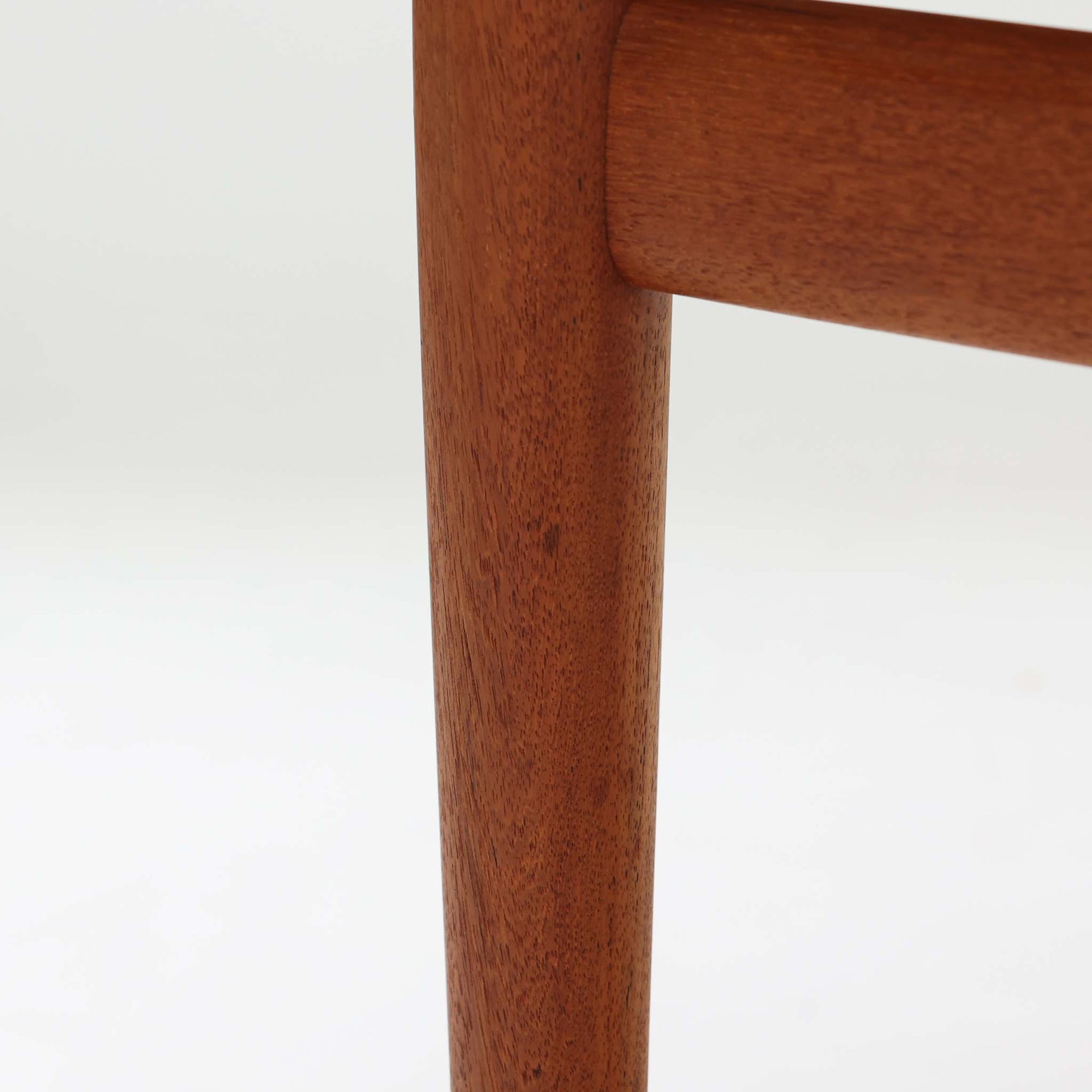 Grete Jalkがデザインし、Glostrup Mobelfabrikで製作されたこちらのセンターテーブルは、端正なプロポーションと軽やかな構造が魅力の北欧ビンテージ品です。幅160cmのゆとりある天板下にはスラット状の棚板を備え、雑誌やブランケットなどを整理しながら使える実用性も兼ね備えています。丸みを帯びた脚部や天板縁の丁寧な仕上げからは、女性デザイナーらしい繊細な美意識と当時の高い木工技術が感じられ、経年により深みを増した木肌が空間に落ち着いた存在感をもたらします。