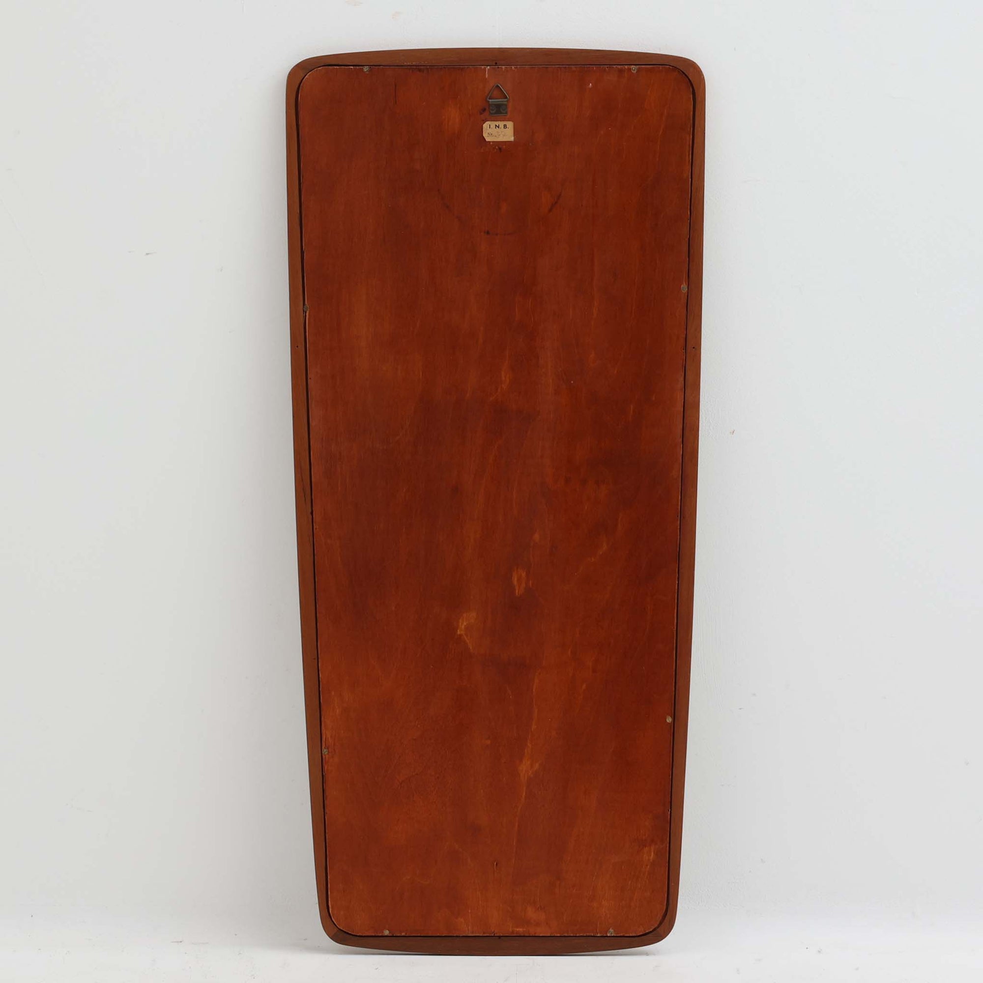 デンマーク製壁掛け／立掛けミラーです。チーク材のフレームは角に丸みをもたせた柔らかなデザインで、北欧らしいシンプルで温かみのある雰囲気を漂わせます。無駄のない細身のフレームが鏡面を引き立て、空間を広く明るく見せてくれます。壁に掛けても、床に立て掛けても美しく、玄関や寝室などさまざまなシーンで活躍します。経年により深みを増した木肌が味わい深く、北欧ビンテージならではの上質な存在感を放つ一品です。