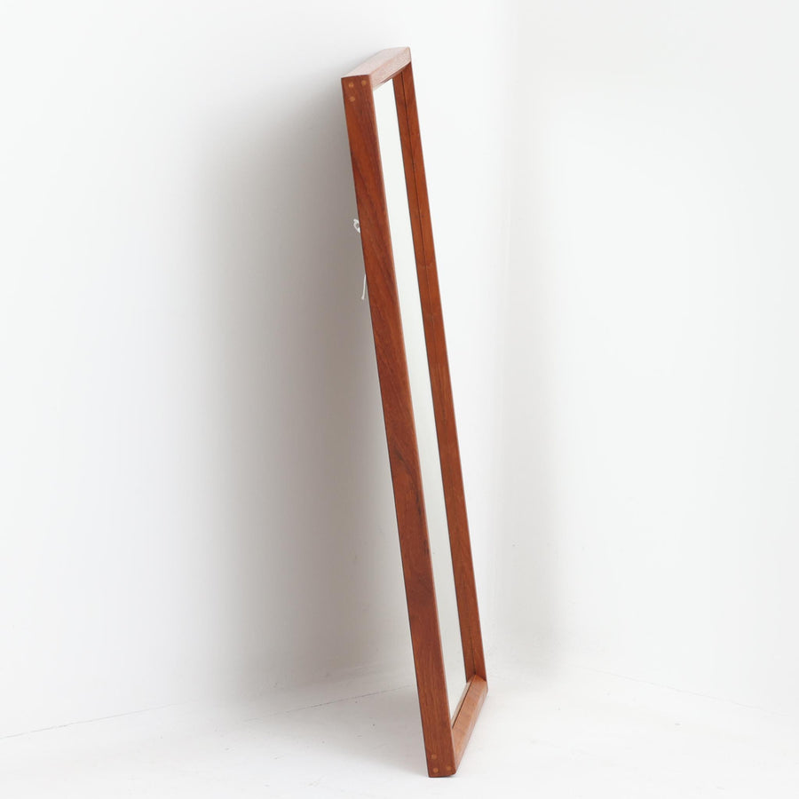 デンマークの名匠Kai Kristiansen（カイ・クリスチャンセン）がAksel Kjersgaard（アクセル・キアスゴー）社のためにデザインした立て掛けミラー「No.143」です。上質なチーク材を用い、木組みの美しい仕口や細身のフレームラインから職人技の高さが感じられます。経年により深みを増した色合いと滑らかな艶が魅力で、玄関や寝室、リビングなど、空間に上品な北欧の温もりをもたらします。背面には壁掛け用金具も備わっていますが、重量があるため立て掛けでのご使用をおすすめします。