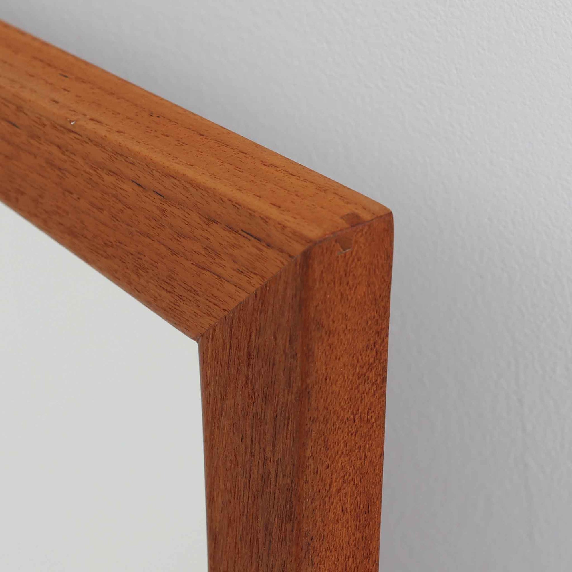 Kai Kristiansen（カイ・クリスチャンセン）がデザインし、Aksel Kjersgaard（アクセル・キアスゴー）社より製造されたNo.103の立て掛けミラーです。柔らかな曲線を描くチーク材のフレームは、丁寧な接合と美しい木目が際立ち、北欧デザインの洗練された職人技を感じさせます。無駄のないシルエットは空間を選ばず、壁掛けとしても立て掛けとしてもお使いいただけます。経年による深みのある色合いがチーク材の魅力を一層引き立て、玄関や寝室に上質な雰囲気を添える一品です。