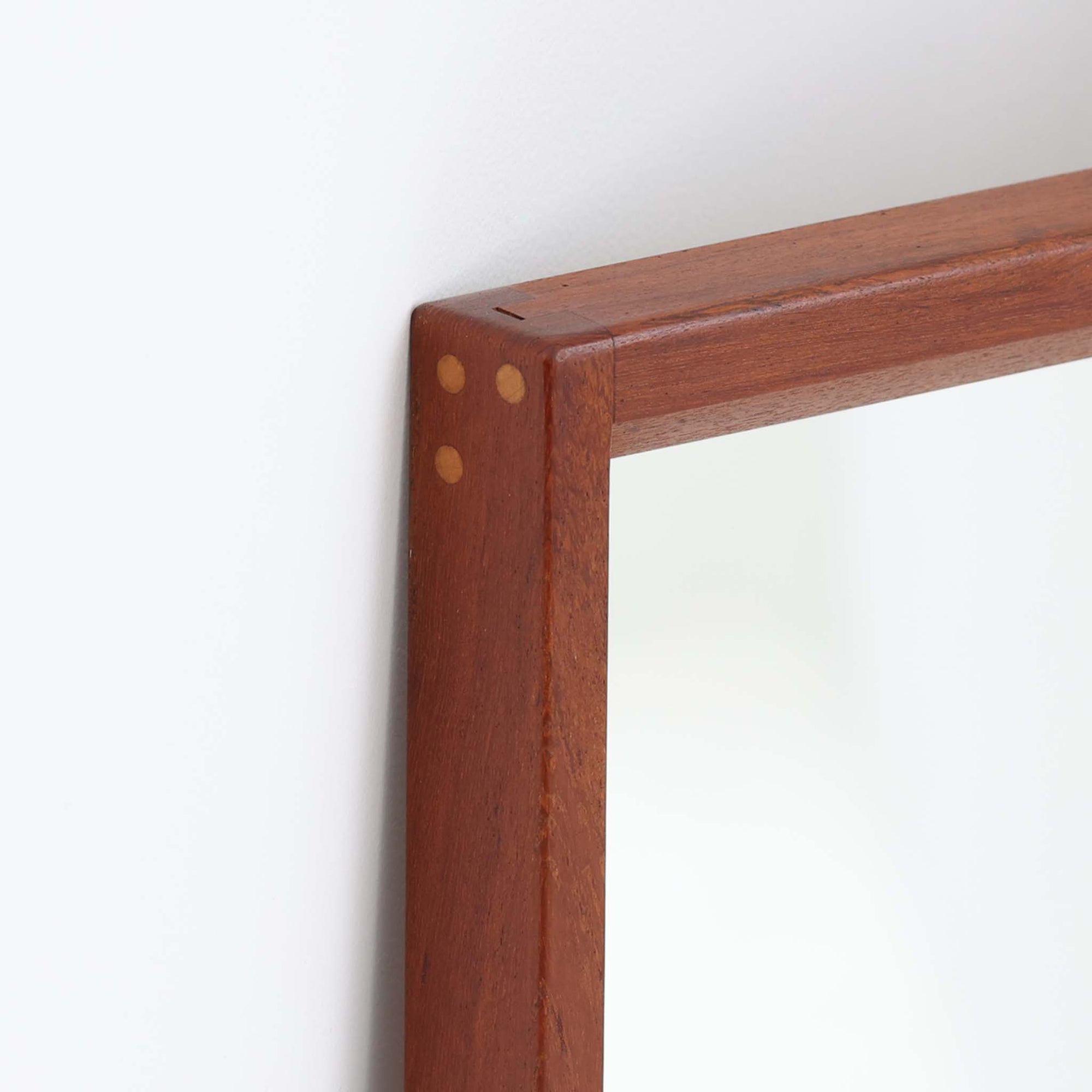 デンマークのデザイナー、Kai Kristiansen（カイ・クリスチャンセン）がAksel Kjersgaard（アクセル・キアスゴー）社のために手がけた立て掛けミラー「No.145」です。チーク材の美しい木目を活かしたフレームは細部まで丁寧に仕上げられ、角の木栓や滑らかな面取りなど北欧家具らしい繊細な職人技が光ります。高さ104cmと程よいサイズ感で、玄関や寝室、リビングなど幅広い空間に馴染みます。背面には壁掛け用の金具が付属していますが、重量があるため立て掛けでの使用をおすすめします。経年により深みを増したチークの質感が空間に温かみを添えるビンテージアイテムです。