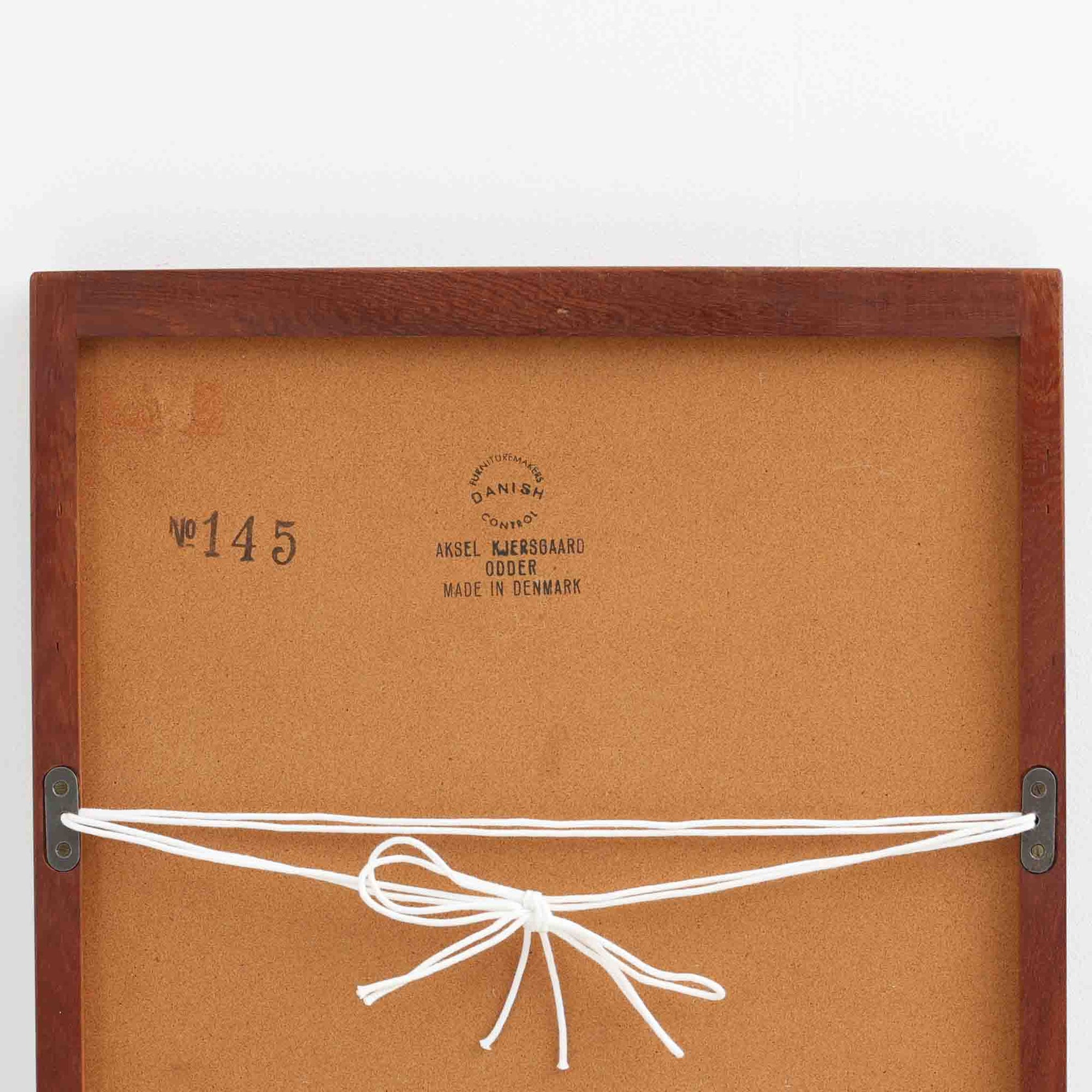 デンマークのデザイナー、Kai Kristiansen（カイ・クリスチャンセン）がAksel Kjersgaard（アクセル・キアスゴー）社のために手がけた立て掛けミラー「No.145」です。チーク材の美しい木目を活かしたフレームは細部まで丁寧に仕上げられ、角の木栓や滑らかな面取りなど北欧家具らしい繊細な職人技が光ります。高さ104cmと程よいサイズ感で、玄関や寝室、リビングなど幅広い空間に馴染みます。背面には壁掛け用の金具が付属していますが、重量があるため立て掛けでの使用をおすすめします。経年により深みを増したチークの質感が空間に温かみを添えるビンテージアイテムです。