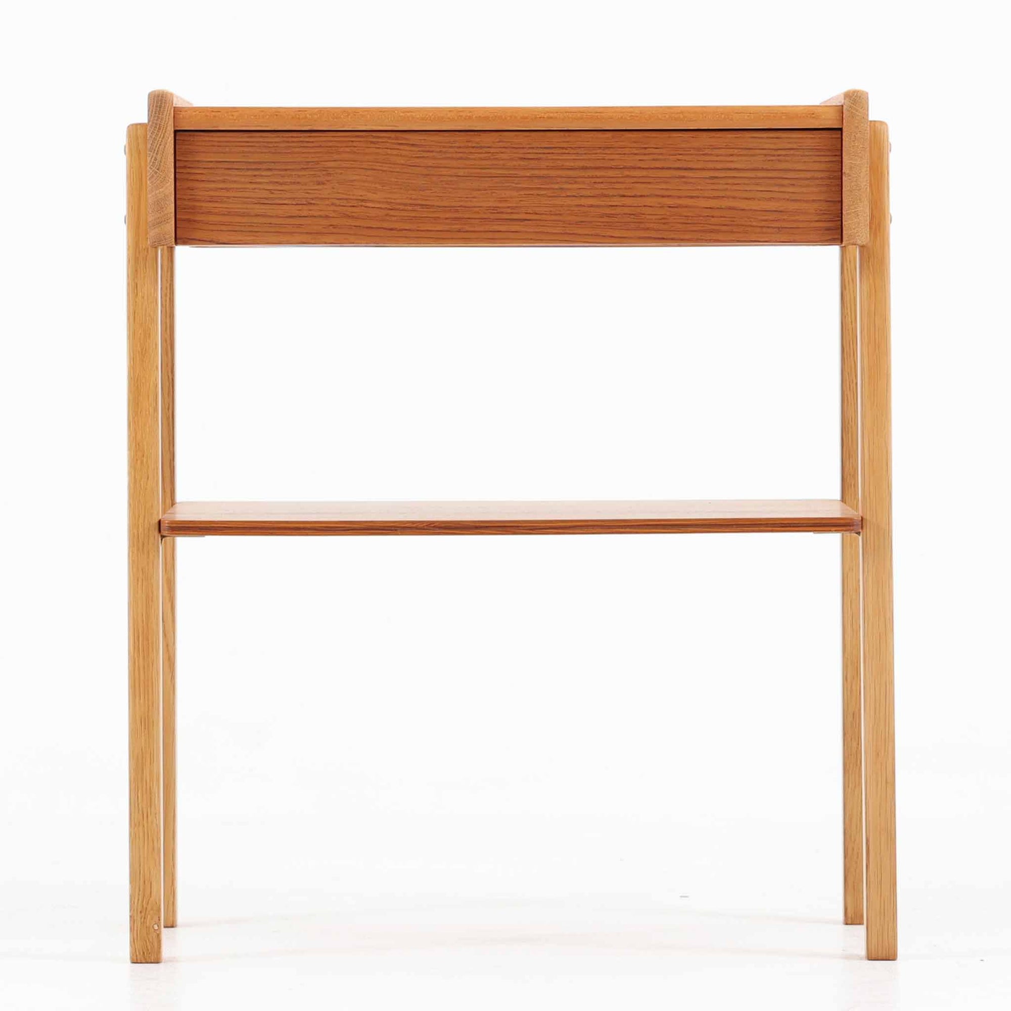 AB Carlstrom＆CO Mobelfabrik社製のサイドチェストは、チーク材とオーク材を組み合わせた北欧ビンテージ家具です。温かみのあるチークの引き出し前板と、明るいオークのフレームが美しいコントラストを生み出し、軽やかで洗練された印象を与えます。上段には小物収納に便利な引き出し、下段にはオープンシェルフを備え、実用性とデザイン性を両立。幅46cmとコンパクトなサイズ感は、ベッドサイドやソファ横でのサイドテーブルとしても最適で、限られたスペースにも収まりやすい設計です。シンプルながら素材の質感と北欧家具ならではの職人技が息づく一台で、空間に温もりと個性を添えてくれます。