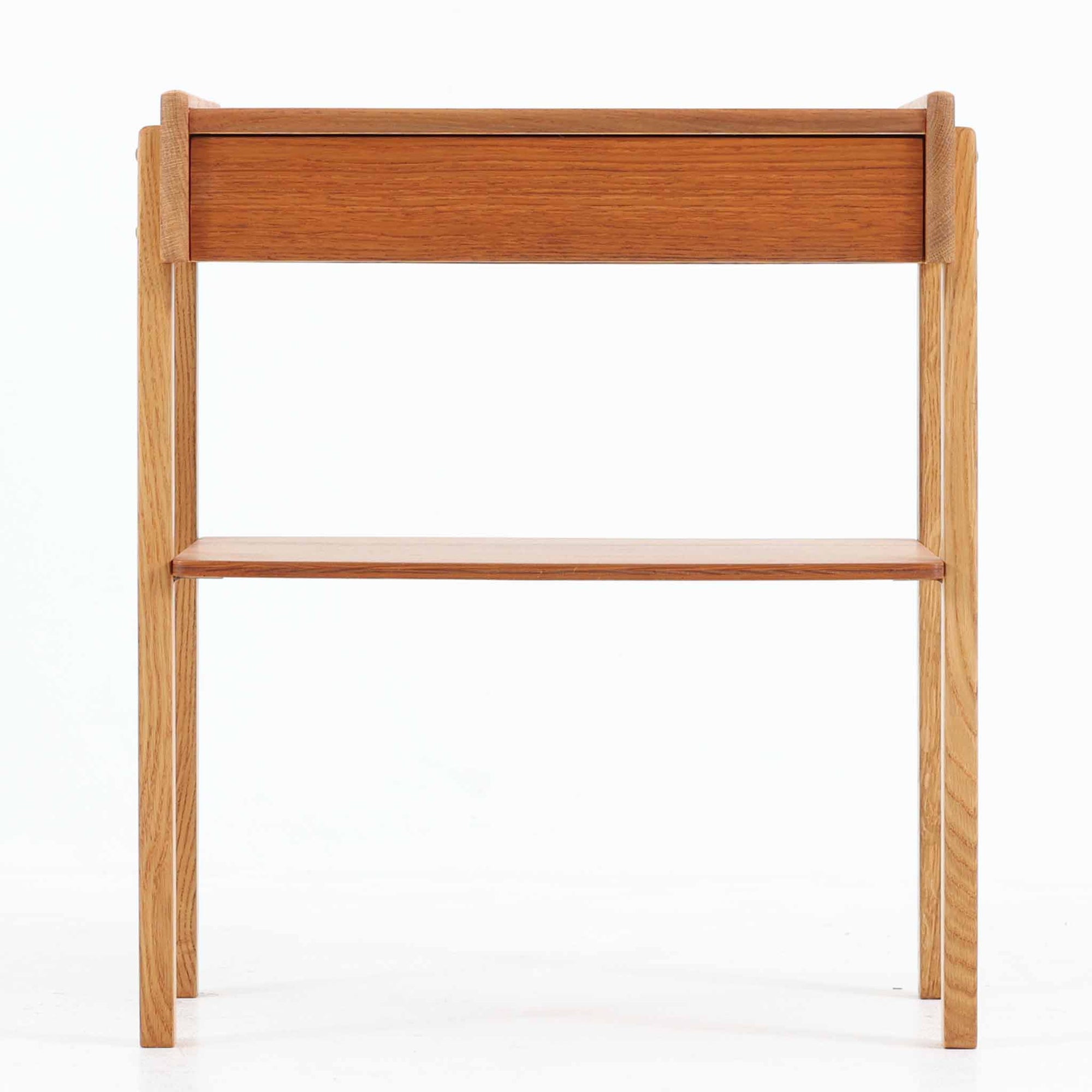 AB Carlstrom＆CO Mobelfabrik社製のサイドチェストは、チーク材とオーク材を組み合わせた北欧ビンテージ家具です。温かみのあるチークの引き出し前板と、明るいオークのフレームが美しいコントラストを生み出し、軽やかで洗練された印象を与えます。上段には小物収納に便利な引き出し、下段にはオープンシェルフを備え、実用性とデザイン性を両立。幅46cmとコンパクトなサイズ感は、ベッドサイドやソファ横でのサイドテーブルとしても最適で、限られたスペースにも収まりやすい設計です。シンプルながら素材の質感と北欧家具ならではの職人技が息づく一台で、空間に温もりと個性を添えてくれます。