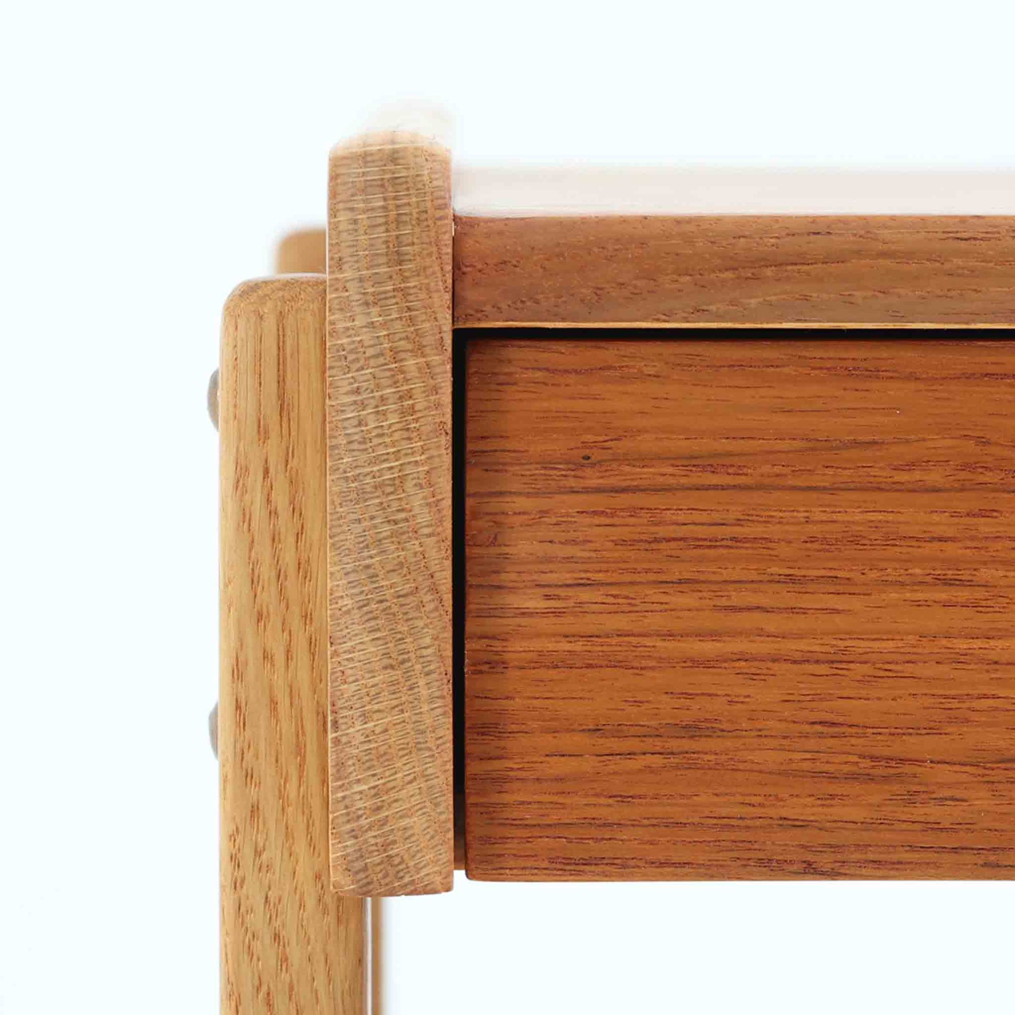 AB Carlstrom＆CO Mobelfabrik社製のサイドチェストは、チーク材とオーク材を組み合わせた北欧ビンテージ家具です。温かみのあるチークの引き出し前板と、明るいオークのフレームが美しいコントラストを生み出し、軽やかで洗練された印象を与えます。上段には小物収納に便利な引き出し、下段にはオープンシェルフを備え、実用性とデザイン性を両立。幅46cmとコンパクトなサイズ感は、ベッドサイドやソファ横でのサイドテーブルとしても最適で、限られたスペースにも収まりやすい設計です。シンプルながら素材の質感と北欧家具ならではの職人技が息づく一台で、空間に温もりと個性を添えてくれます。