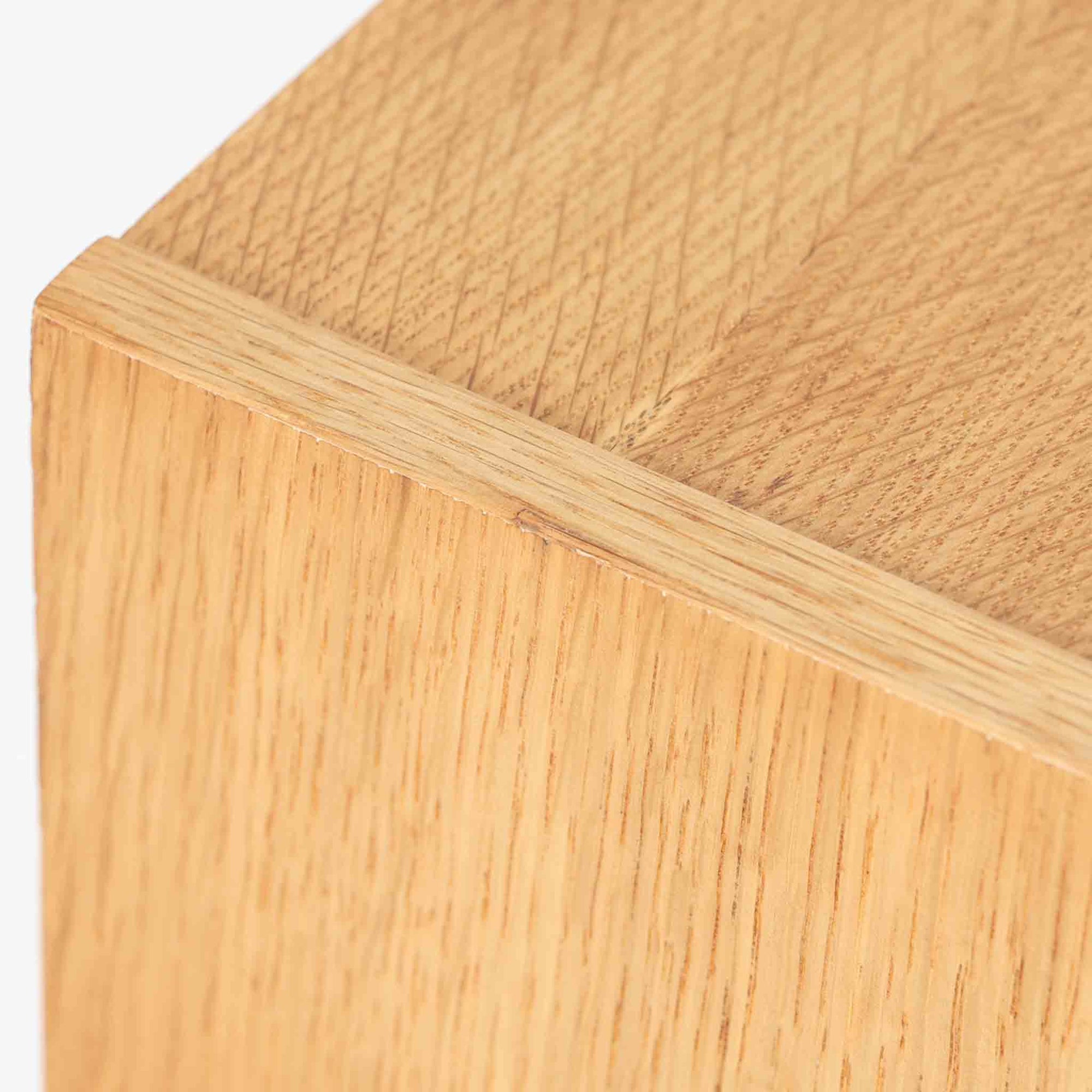 オーク材を用いたこちらの2段チェストは、北欧ビンテージ家具らしいシンプルかつ機能的なデザインが魅力です。直線的なフォルムに対し、細身でテーパーのかかった脚部が軽やかな印象を与え、空間を圧迫せずに置くことができます。幅60cmとコンパクトながら、2杯の引き出しは日用品や小物収納に便利で、ベッドサイドやリビングの補助収納としても最適です。経年により深みを増したオークの木肌が、温もりある雰囲気を演出する一点物です。