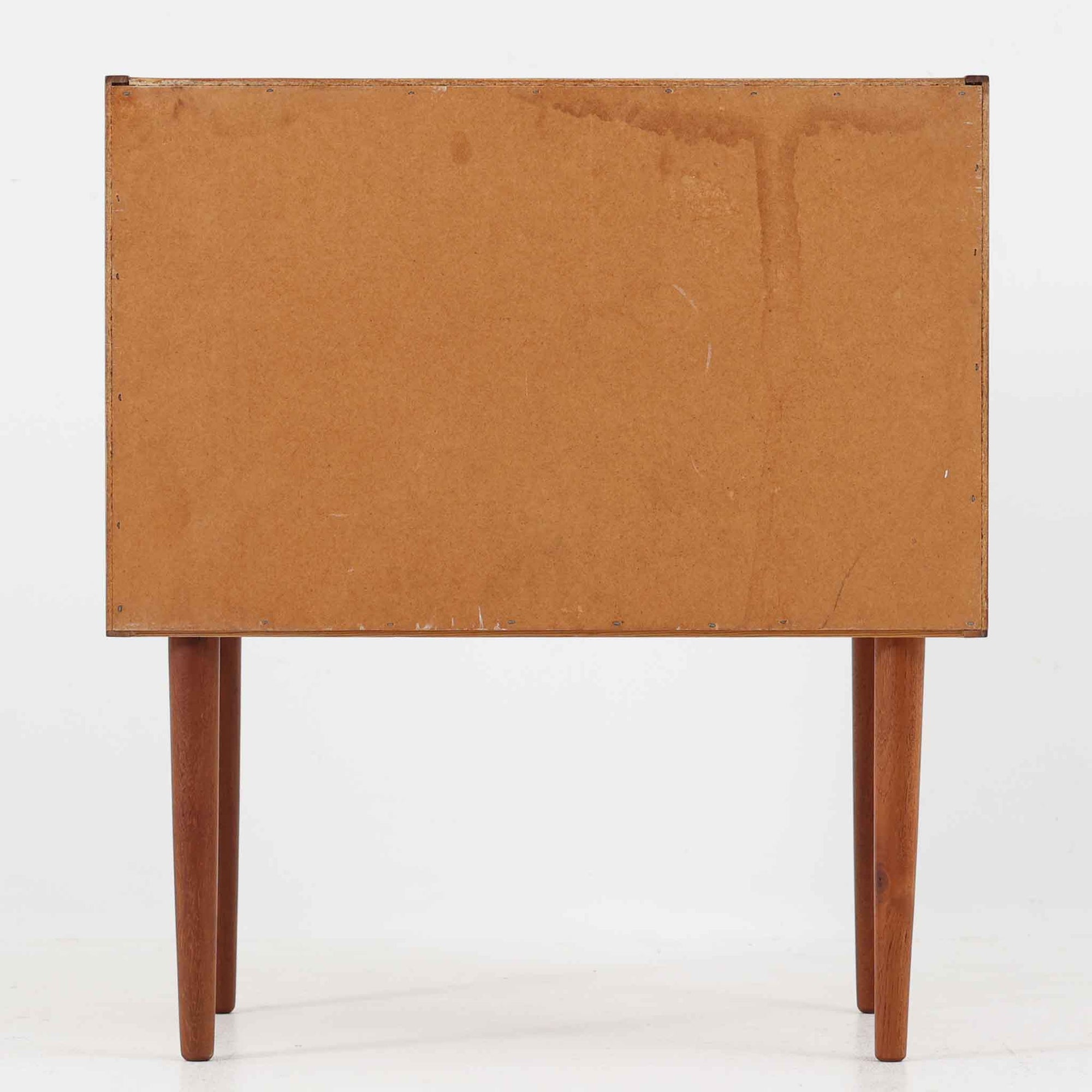 デンマーク製のチーク材を使用した3段チェストです。コンパクトな幅62cmのサイズ感ながら、3杯の引き出しを備え収納力に優れており、リビングや寝室、玄関先など幅広いシーンで活躍します。スクエア型の取っ手は彫り込みデザインで指掛かりが良く、シンプルながらも北欧家具らしい温もりと実用性を感じさせます。経年により深みを増したチーク材の色合いが、空間に落ち着きと上質な雰囲気をもたらし、ビンテージならではの魅力を楽しめる一台です。