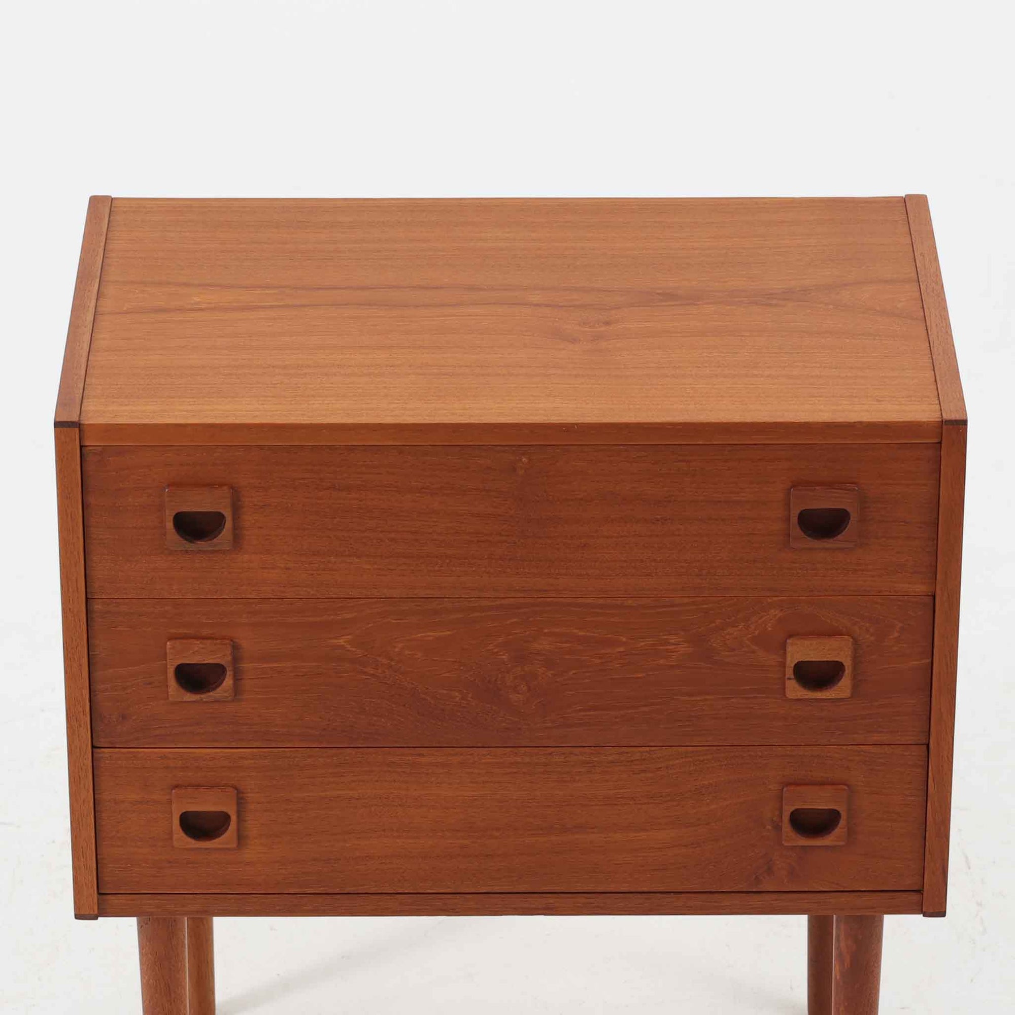 デンマーク製のチーク材を使用した3段チェストです。コンパクトな幅62cmのサイズ感ながら、3杯の引き出しを備え収納力に優れており、リビングや寝室、玄関先など幅広いシーンで活躍します。スクエア型の取っ手は彫り込みデザインで指掛かりが良く、シンプルながらも北欧家具らしい温もりと実用性を感じさせます。経年により深みを増したチーク材の色合いが、空間に落ち着きと上質な雰囲気をもたらし、ビンテージならではの魅力を楽しめる一台です。