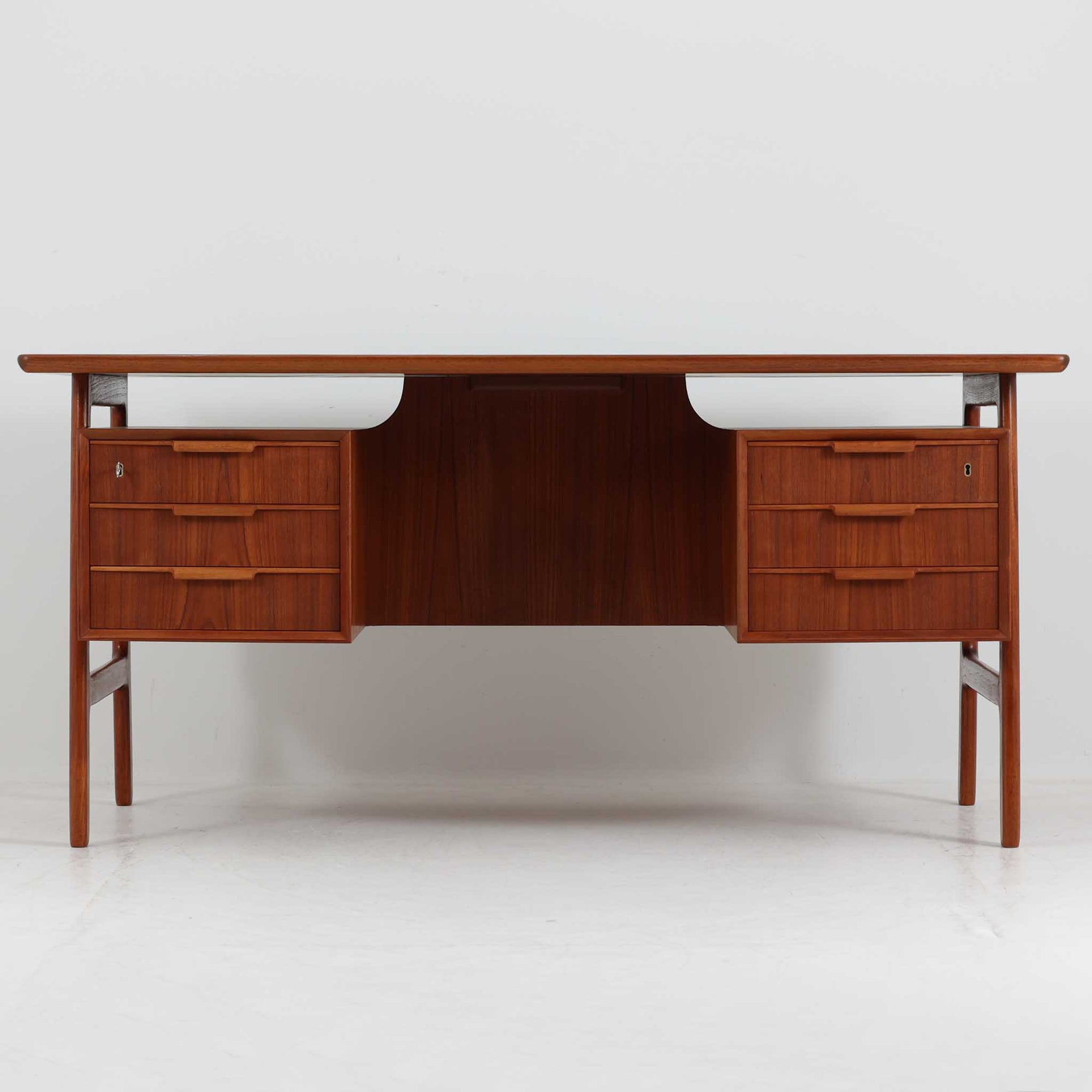 Omann Jun（オーマン・ユン）によるデザインで、同社から製造された両袖デスク「Model 75」です。チーク材の温かみある木目と、滑らかなエッジを描く天板ラインが美しく、北欧家具らしい上質な佇まいを感じさせます。左右に3段ずつ備えた引き出しは、実用性に優れながらも取手のデザインがアクセントとなっており、職人の細やかな技術が光ります。背面にも収納スペースが設けられており、空間の中央に置いても絵になる仕上がりです。ワークスペースや書斎に品格を添える、北欧ビンテージの名品デスクです。