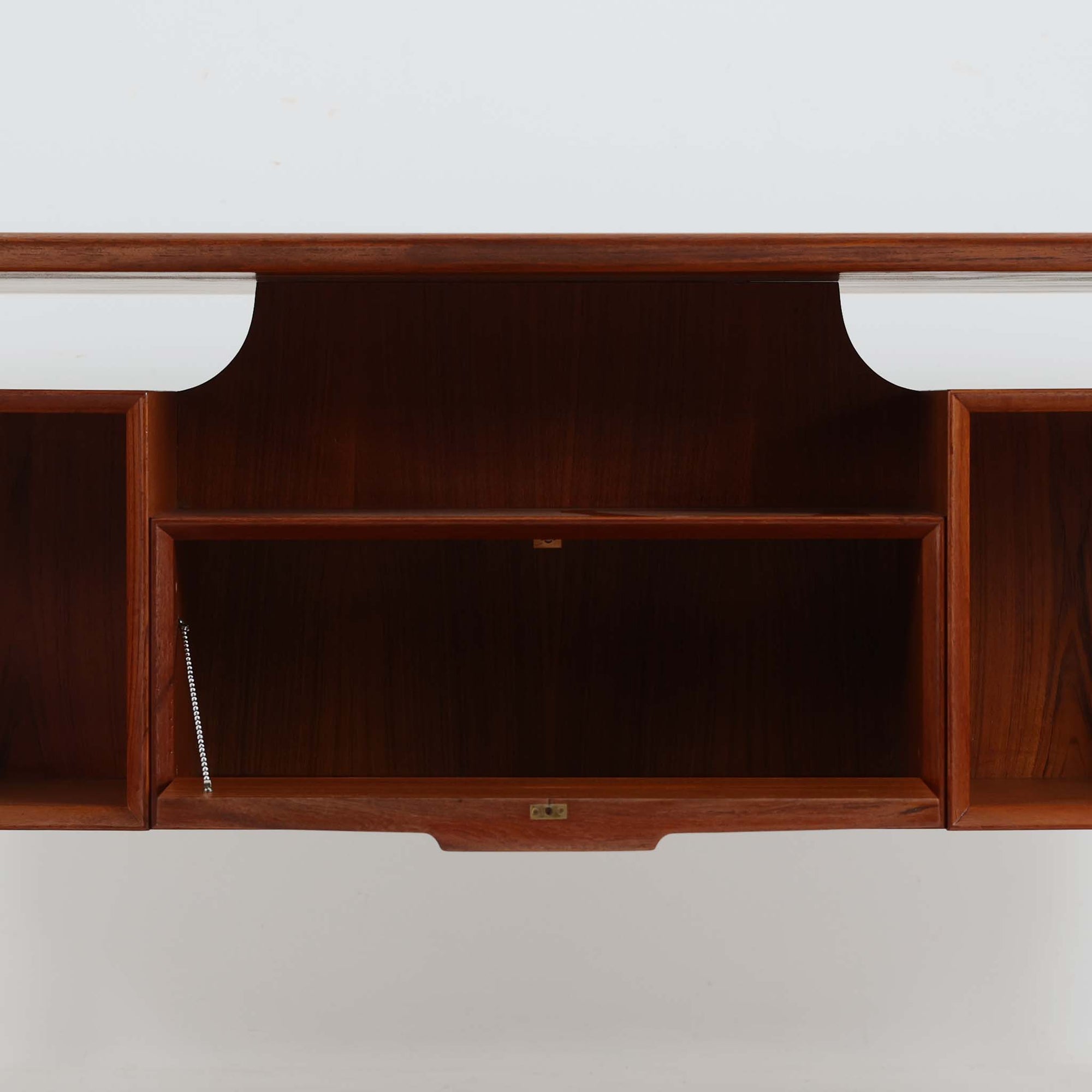 Omann Jun（オーマン・ユン）によるデザインで、同社から製造された両袖デスク「Model 75」です。チーク材の温かみある木目と、滑らかなエッジを描く天板ラインが美しく、北欧家具らしい上質な佇まいを感じさせます。左右に3段ずつ備えた引き出しは、実用性に優れながらも取手のデザインがアクセントとなっており、職人の細やかな技術が光ります。背面にも収納スペースが設けられており、空間の中央に置いても絵になる仕上がりです。ワークスペースや書斎に品格を添える、北欧ビンテージの名品デスクです。