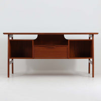 Omann Jun（オーマン・ユン）によるデザインで、同社から製造された両袖デスク「Model 75」です。チーク材の温かみある木目と、滑らかなエッジを描く天板ラインが美しく、北欧家具らしい上質な佇まいを感じさせます。左右に3段ずつ備えた引き出しは、実用性に優れながらも取手のデザインがアクセントとなっており、職人の細やかな技術が光ります。背面にも収納スペースが設けられており、空間の中央に置いても絵になる仕上がりです。ワークスペースや書斎に品格を添える、北欧ビンテージの名品デスクです。