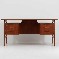 Omann Jun（オーマン・ユン）によるデザインで、同社から製造された両袖デスク「Model 75」です。チーク材の温かみある木目と、滑らかなエッジを描く天板ラインが美しく、北欧家具らしい上質な佇まいを感じさせます。左右に3段ずつ備えた引き出しは、実用性に優れながらも取手のデザインがアクセントとなっており、職人の細やかな技術が光ります。背面にも収納スペースが設けられており、空間の中央に置いても絵になる仕上がりです。ワークスペースや書斎に品格を添える、北欧ビンテージの名品デスクです。