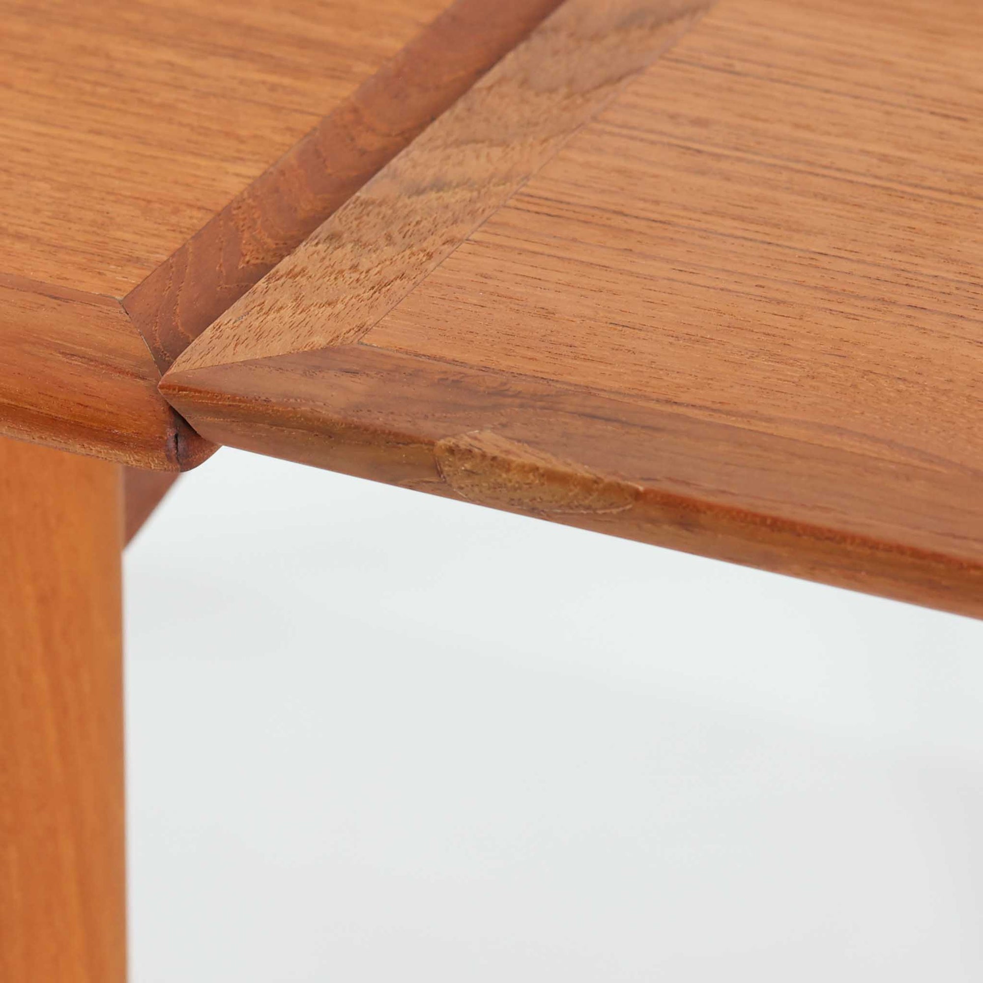 北欧らしい実用性と素材の良さが感じられる正方形エクステンションテーブルです。天板には良質なチーク材が用いられ、赤みのある木目と滑らかな手触りが、経年変化による深みとともに味わいを増しています。通常時はコンパクトなサイズ感で使いやすく、左右の補助天板を引き出すことで来客時や食事人数に応じて柔軟に対応できる構造です。脚部は細身で圧迫感がなく、幕板の緩やかな曲線が全体にやわらかな印象を与え、ダイニングはもちろんワークテーブルとしてもおすすめです。