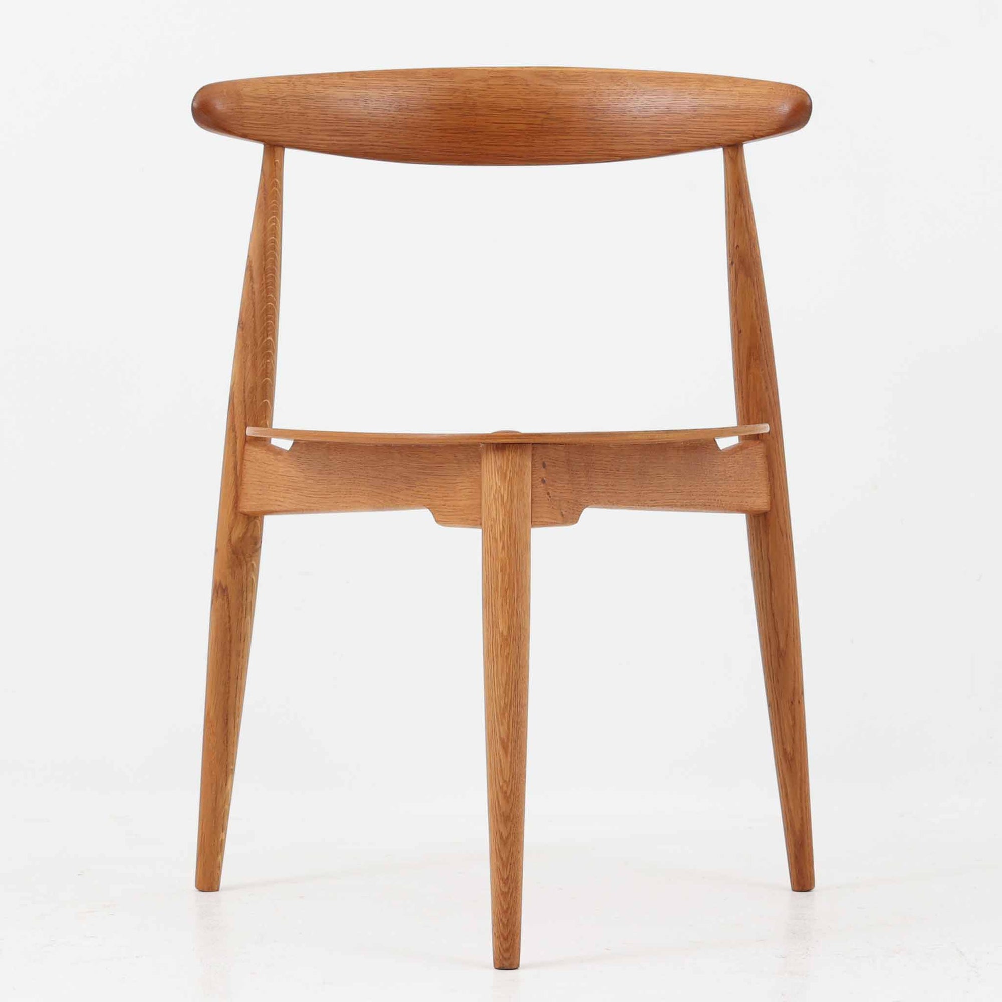 Hans J. Wegnerがデザインし、Fritz Hansen社より発表されたFH4103チェアは、三角形に近い座面と滑らかな曲線を描く笠木が特徴の北欧ビンテージ家具です。フレームには堅牢なオーク材、座面には温かみあるチーク材を組み合わせ、素材のコントラストが美しいバランスを生み出しています。彫刻的なフォルムながら軽やかで実用的な構造は、ダイニングチェアとしてはもちろん、空間のアクセントピースとしても存在感を放ちます。経年による木肌の深い風合いが、ビンテージならではの魅力を引き立てています。
