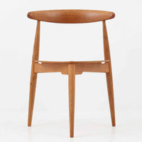 Hans J. Wegnerがデザインし、Fritz Hansen社より発表されたFH4103チェアは、三角形に近い座面と滑らかな曲線を描く笠木が特徴の北欧ビンテージ家具です。フレームには堅牢なオーク材、座面には温かみあるチーク材を組み合わせ、素材のコントラストが美しいバランスを生み出しています。彫刻的なフォルムながら軽やかで実用的な構造は、ダイニングチェアとしてはもちろん、空間のアクセントピースとしても存在感を放ちます。経年による木肌の深い風合いが、ビンテージならではの魅力を引き立てています。