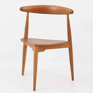 Hans J. Wegnerがデザインし、Fritz Hansen社より発表されたFH4103チェアは、三角形に近い座面と滑らかな曲線を描く笠木が特徴の北欧ビンテージ家具です。フレームには堅牢なオーク材、座面には温かみあるチーク材を組み合わせ、素材のコントラストが美しいバランスを生み出しています。彫刻的なフォルムながら軽やかで実用的な構造は、ダイニングチェアとしてはもちろん、空間のアクセントピースとしても存在感を放ちます。経年による木肌の深い風合いが、ビンテージならではの魅力を引き立てています。