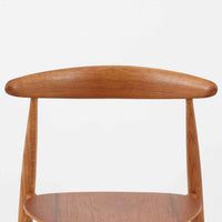 Hans J. Wegnerがデザインし、Fritz Hansen社より発表されたFH4103チェアは、三角形に近い座面と滑らかな曲線を描く笠木が特徴の北欧ビンテージ家具です。フレームには堅牢なオーク材、座面には温かみあるチーク材を組み合わせ、素材のコントラストが美しいバランスを生み出しています。彫刻的なフォルムながら軽やかで実用的な構造は、ダイニングチェアとしてはもちろん、空間のアクセントピースとしても存在感を放ちます。経年による木肌の深い風合いが、ビンテージならではの魅力を引き立てています。