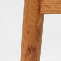 Hans J. Wegnerがデザインし、Fritz Hansen社より発表されたFH4103チェアは、三角形に近い座面と滑らかな曲線を描く笠木が特徴の北欧ビンテージ家具です。フレームには堅牢なオーク材、座面には温かみあるチーク材を組み合わせ、素材のコントラストが美しいバランスを生み出しています。彫刻的なフォルムながら軽やかで実用的な構造は、ダイニングチェアとしてはもちろん、空間のアクセントピースとしても存在感を放ちます。経年による木肌の深い風合いが、ビンテージならではの魅力を引き立てています。