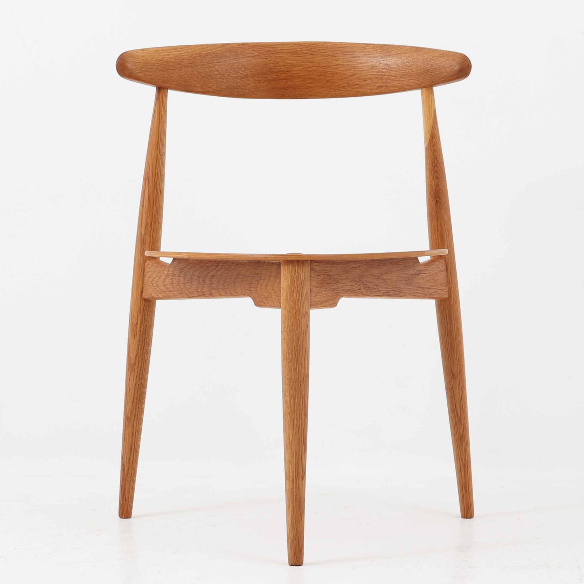 Hans J. Wegnerがデザインし、Fritz Hansen社より発表されたFH4103チェアは、三角形に近い座面と滑らかな曲線を描く笠木が特徴の北欧ビンテージ家具です。フレームには堅牢なオーク材、座面には温かみあるチーク材を組み合わせ、素材のコントラストが美しいバランスを生み出しています。彫刻的なフォルムながら軽やかで実用的な構造は、ダイニングチェアとしてはもちろん、空間のアクセントピースとしても存在感を放ちます。経年による木肌の深い風合いが、ビンテージならではの魅力を引き立てています。