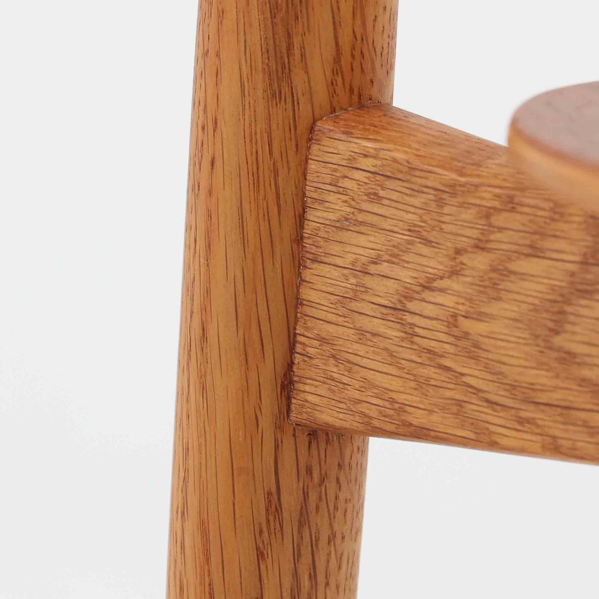 Hans J. Wegnerがデザインし、Fritz Hansen社より発表されたFH4103チェアは、三角形に近い座面と滑らかな曲線を描く笠木が特徴の北欧ビンテージ家具です。フレームには堅牢なオーク材、座面には温かみあるチーク材を組み合わせ、素材のコントラストが美しいバランスを生み出しています。彫刻的なフォルムながら軽やかで実用的な構造は、ダイニングチェアとしてはもちろん、空間のアクセントピースとしても存在感を放ちます。経年による木肌の深い風合いが、ビンテージならではの魅力を引き立てています。
