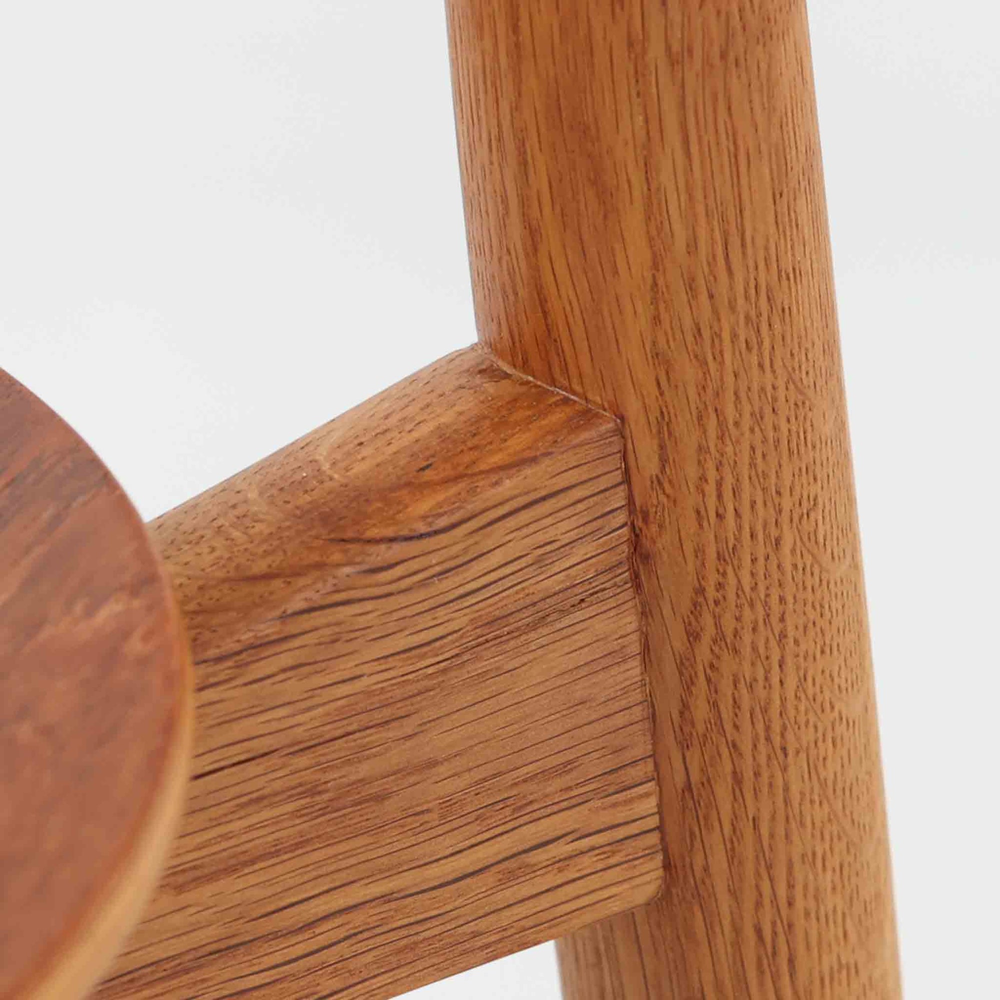 Hans J. Wegnerがデザインし、Fritz Hansen社より発表されたFH4103チェアは、三角形に近い座面と滑らかな曲線を描く笠木が特徴の北欧ビンテージ家具です。フレームには堅牢なオーク材、座面には温かみあるチーク材を組み合わせ、素材のコントラストが美しいバランスを生み出しています。彫刻的なフォルムながら軽やかで実用的な構造は、ダイニングチェアとしてはもちろん、空間のアクセントピースとしても存在感を放ちます。経年による木肌の深い風合いが、ビンテージならではの魅力を引き立てています。