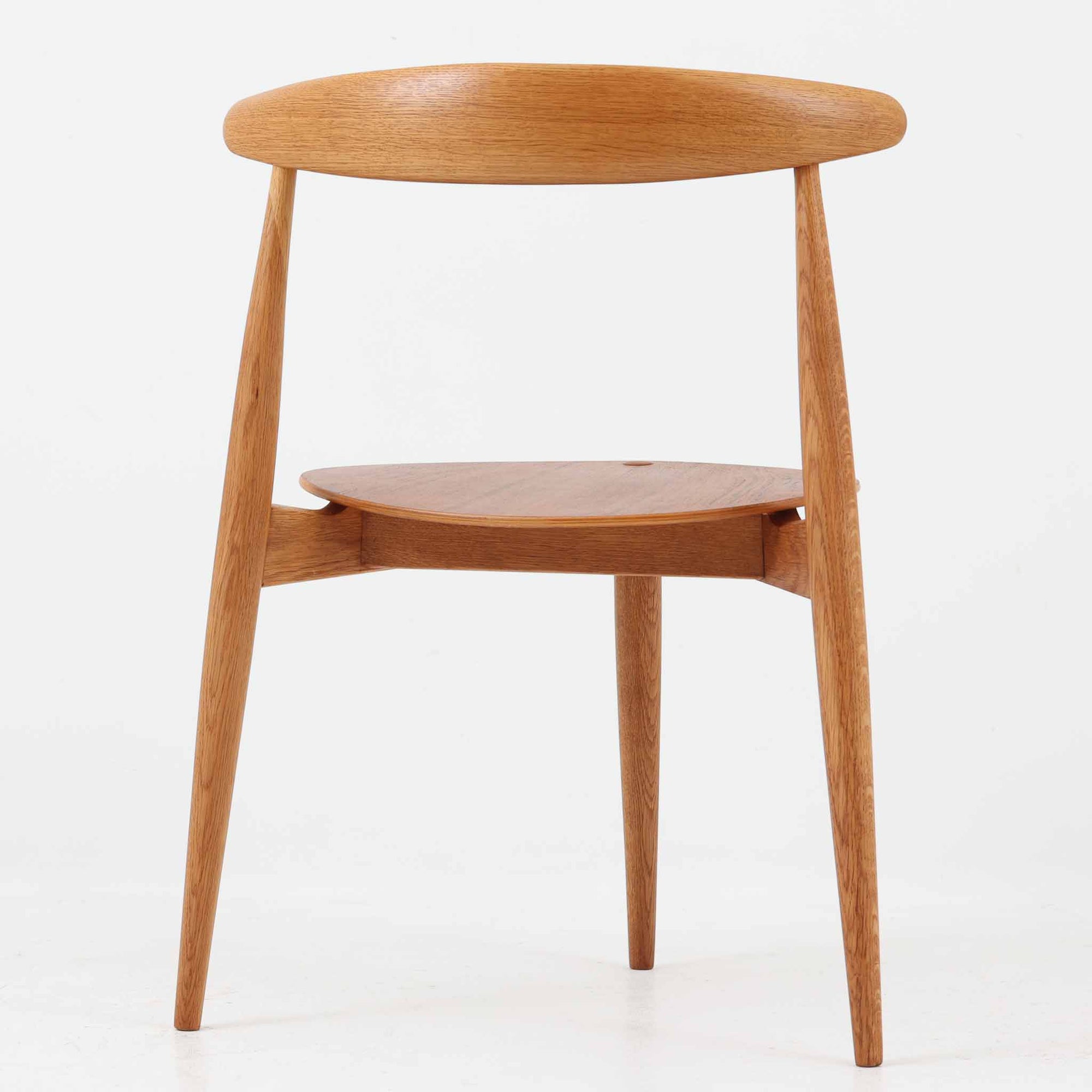 Hans J. Wegnerがデザインし、Fritz Hansen社より発表されたFH4103チェアは、三角形に近い座面と滑らかな曲線を描く笠木が特徴の北欧ビンテージ家具です。フレームには堅牢なオーク材、座面には温かみあるチーク材を組み合わせ、素材のコントラストが美しいバランスを生み出しています。彫刻的なフォルムながら軽やかで実用的な構造は、ダイニングチェアとしてはもちろん、空間のアクセントピースとしても存在感を放ちます。経年による木肌の深い風合いが、ビンテージならではの魅力を引き立てています。