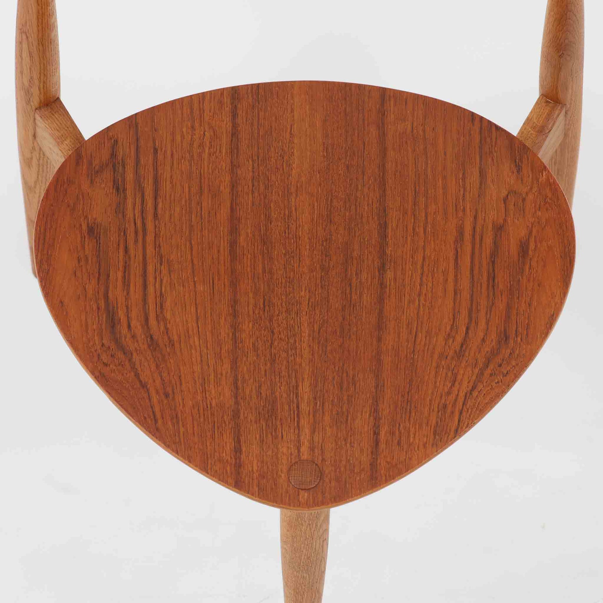 Hans J. Wegnerがデザインし、Fritz Hansen社より発表されたFH4103チェアは、三角形に近い座面と滑らかな曲線を描く笠木が特徴の北欧ビンテージ家具です。フレームには堅牢なオーク材、座面には温かみあるチーク材を組み合わせ、素材のコントラストが美しいバランスを生み出しています。彫刻的なフォルムながら軽やかで実用的な構造は、ダイニングチェアとしてはもちろん、空間のアクセントピースとしても存在感を放ちます。経年による木肌の深い風合いが、ビンテージならではの魅力を引き立てています。