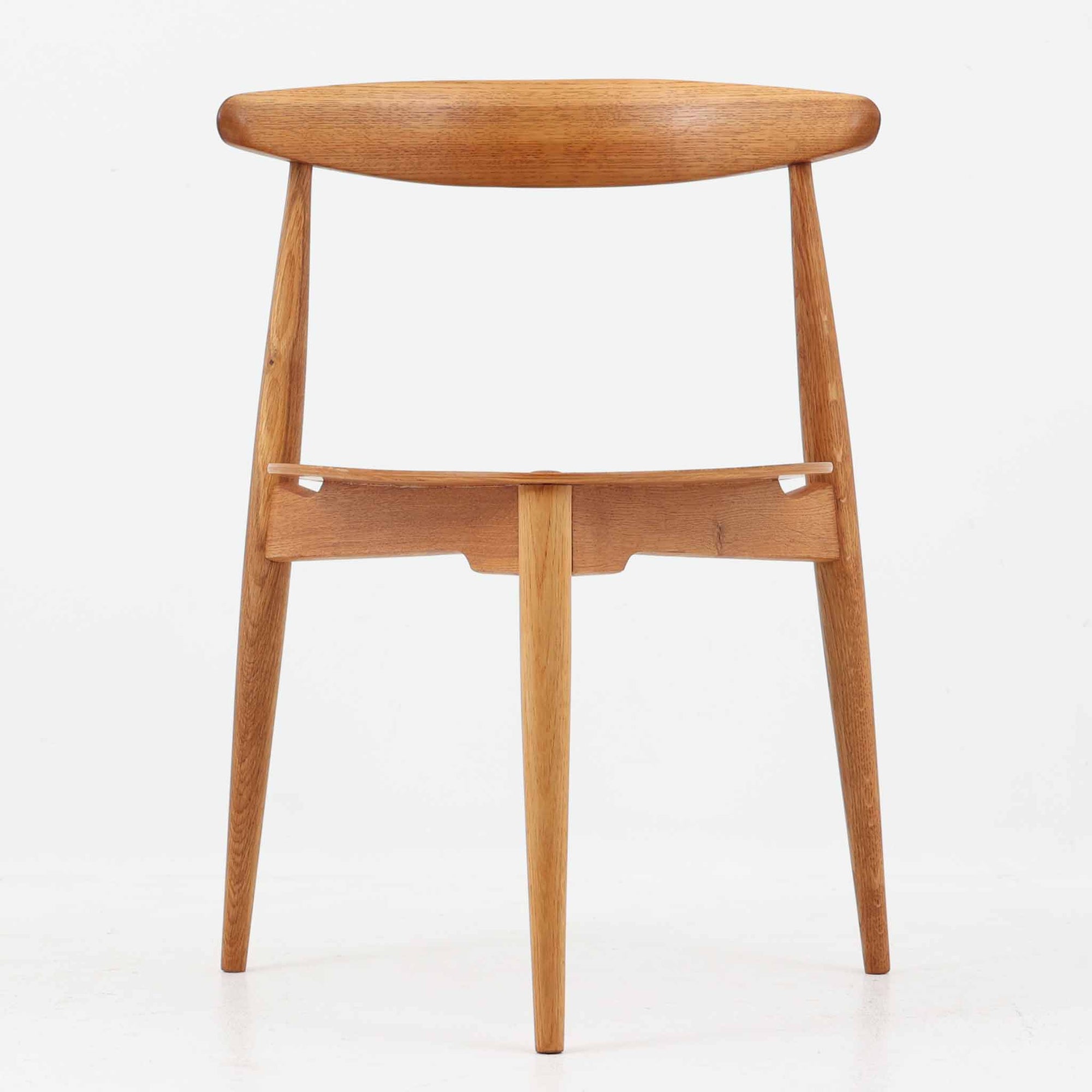 Hans J. Wegnerがデザインし、Fritz Hansen社より発表されたFH4103チェアは、三角形に近い座面と滑らかな曲線を描く笠木が特徴の北欧ビンテージ家具です。フレームには堅牢なオーク材、座面には温かみあるチーク材を組み合わせ、素材のコントラストが美しいバランスを生み出しています。彫刻的なフォルムながら軽やかで実用的な構造は、ダイニングチェアとしてはもちろん、空間のアクセントピースとしても存在感を放ちます。経年による木肌の深い風合いが、ビンテージならではの魅力を引き立てています。
