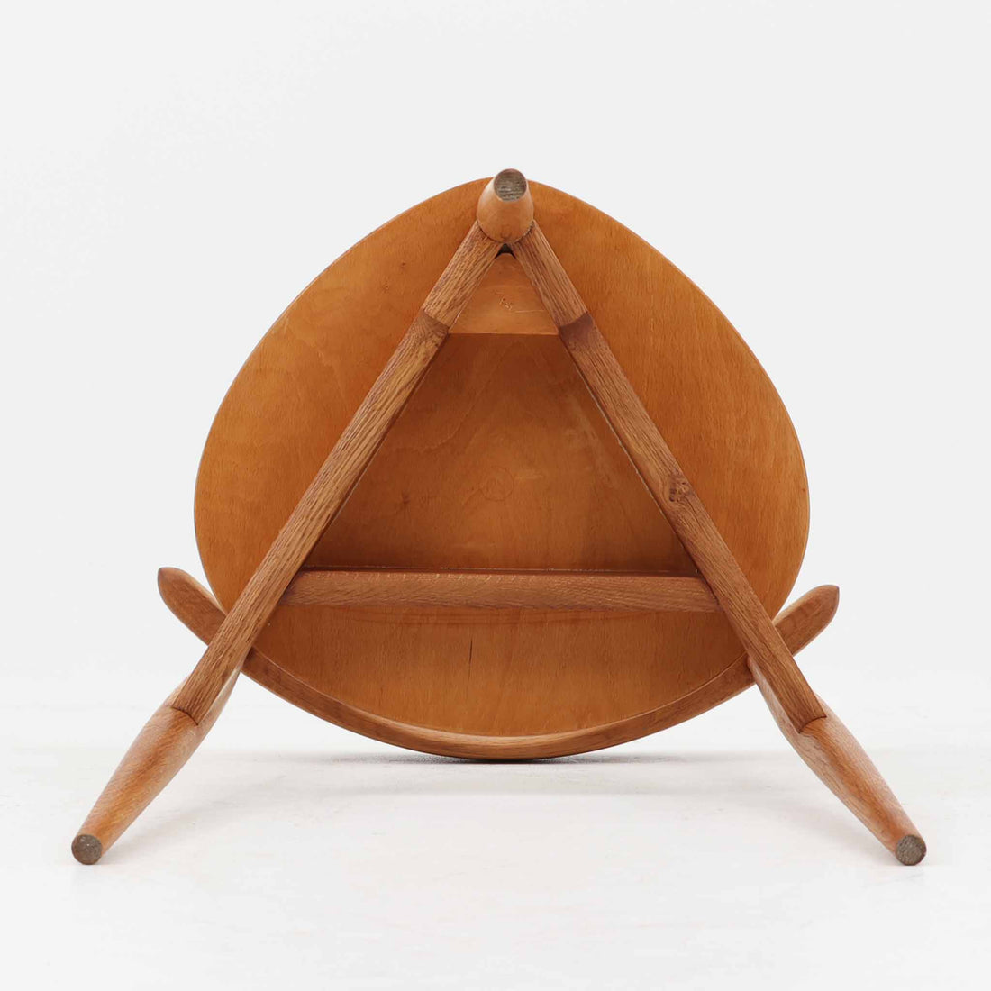 Hans J. Wegnerがデザインし、Fritz Hansen社より発表されたFH4103チェアは、三角形に近い座面と滑らかな曲線を描く笠木が特徴の北欧ビンテージ家具です。フレームには堅牢なオーク材、座面には温かみあるチーク材を組み合わせ、素材のコントラストが美しいバランスを生み出しています。彫刻的なフォルムながら軽やかで実用的な構造は、ダイニングチェアとしてはもちろん、空間のアクセントピースとしても存在感を放ちます。経年による木肌の深い風合いが、ビンテージならではの魅力を引き立てています。